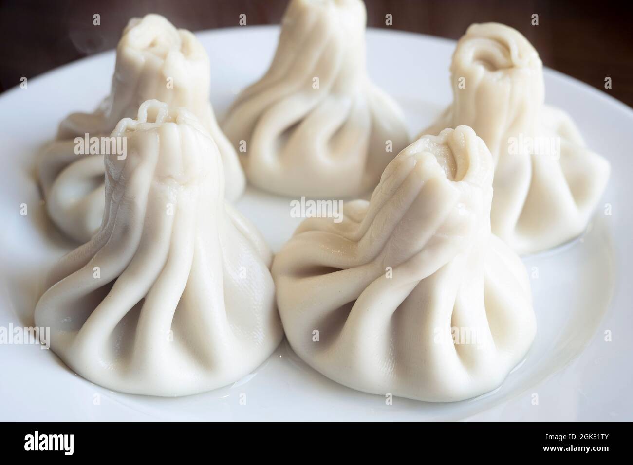 Gekochte khinkali oder kaukasische Knödel auf der keramischen Platte, die Nahaufnahme der gekochten khinkali mit dem Dampf Stockfoto