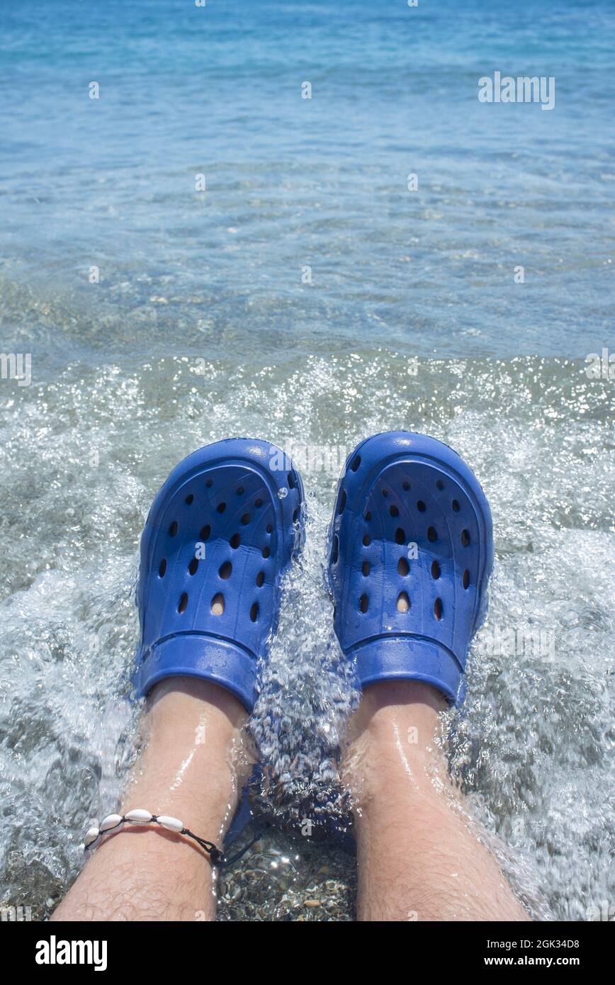 Männer tragen blaue Clogs am Strand. Selektiver Fokus Stockfoto