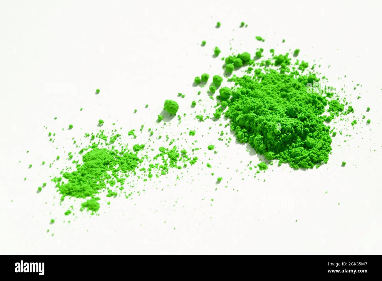 Nahaufnahme eines Teils des grünen Pigments, das auf Weiß isoliert ist. Das Pigment kann als Basis für Make-up verwendet oder mit Leinöl gemischt werden, um Ölfarbe zu machen Stockfoto