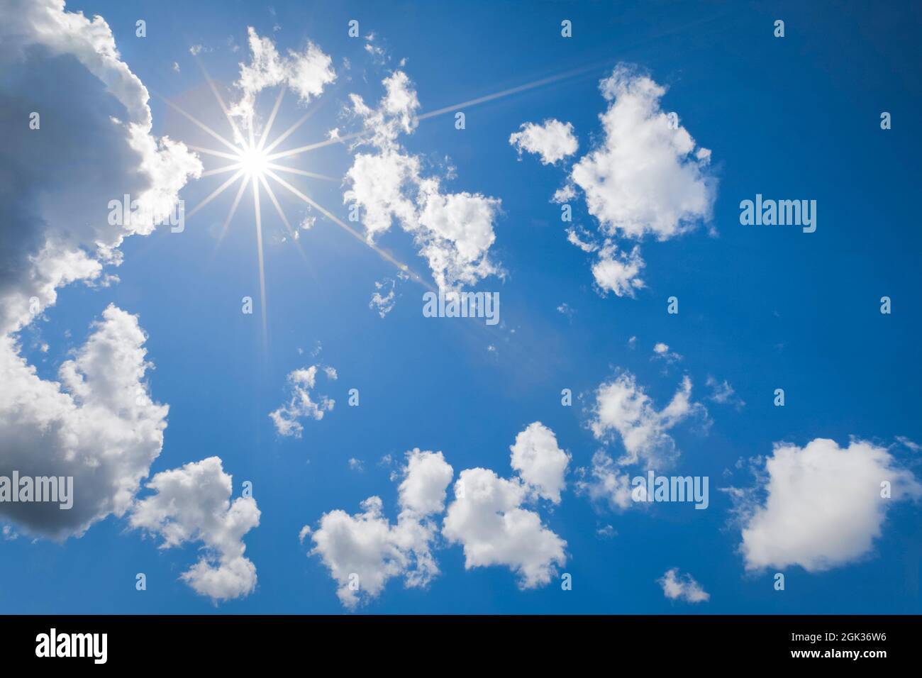 Sonne der blaue Himmel zwischen verstreuten Kumuluswolken, contre-jour. Schweiz.. Stockfoto