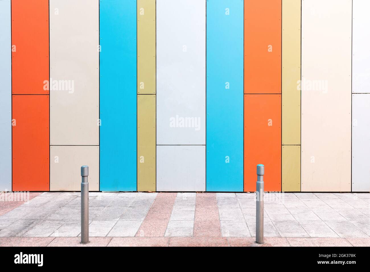 Urbane Szene mit leerer Straße und farbenfroher geometrischer Wand Stockfoto