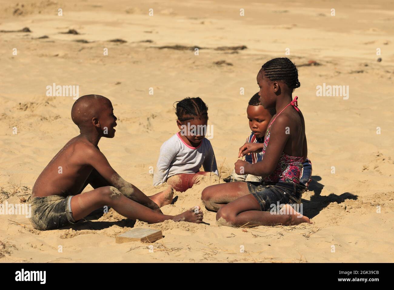 Niedliche schwarze afrikanische Kinder spielen am Strand Stockfoto
