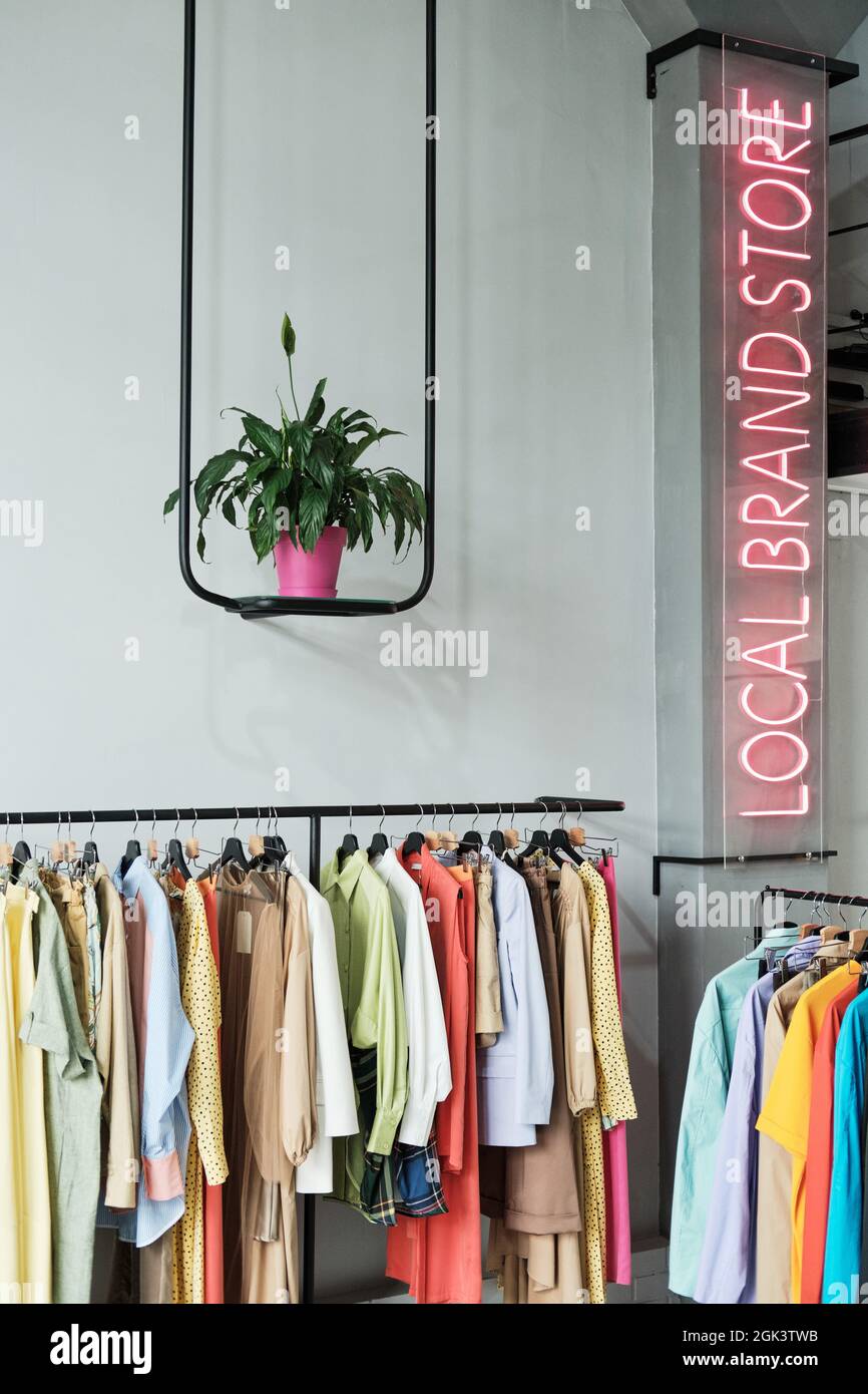 Bild von lokalem Bekleidungsgeschäft mit Mode-Kleidung und beleuchteten Schild an der Wand Stockfoto