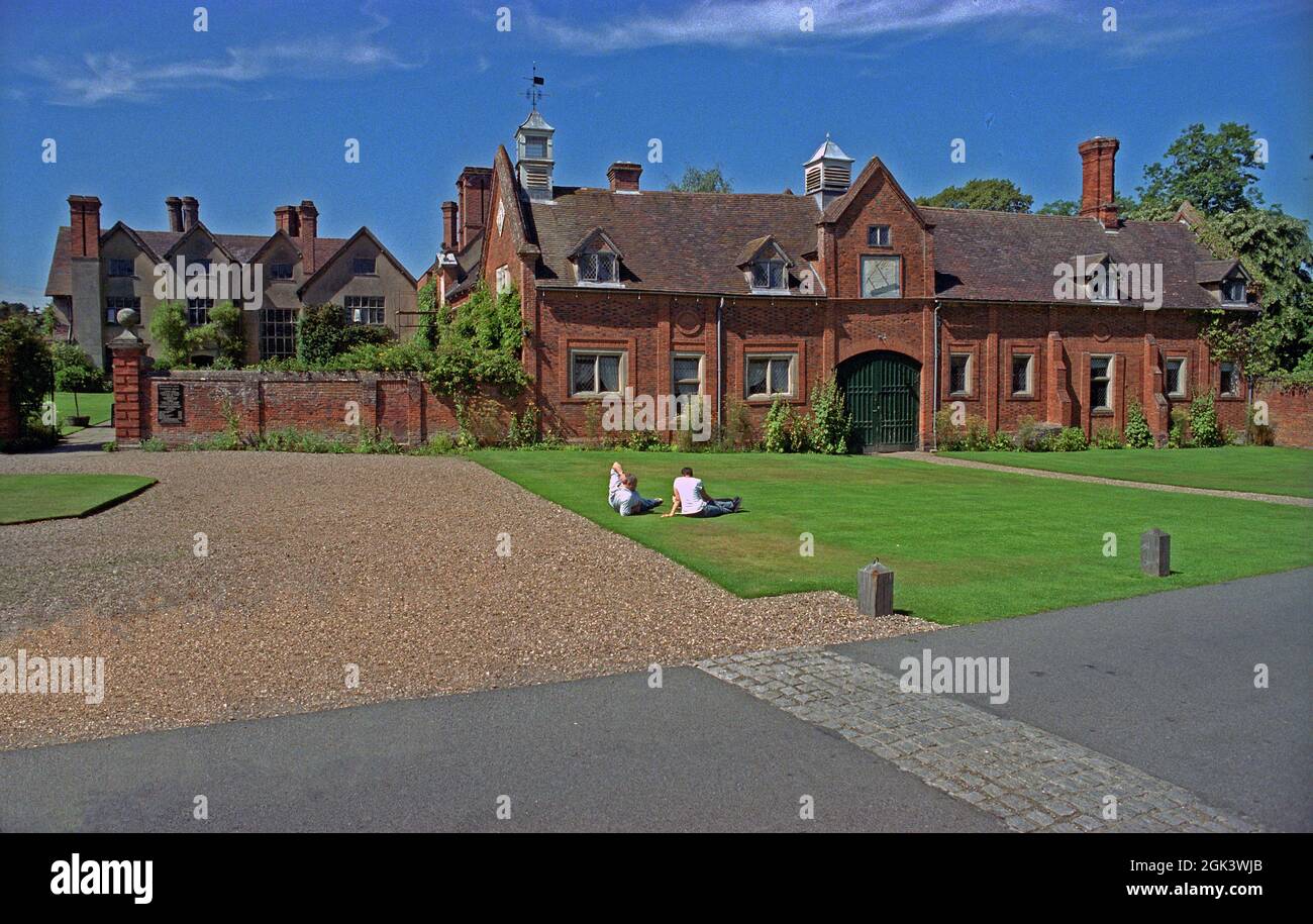 Touristen ruhen sich an einem heißen Augustnachmittag vor dem PACKWOOD HOUSE des National Trust in der Nähe von Solihull, WARWICKSHIRE, auf dem Rasen aus. Packwood House ist ein Fachwerkhaus im Tudor-Herrenhaus in Packwood an der Grenze zu Solihull in der Nähe von Lapworth, Warwickshire. Das Haus gehört seit 1941 dem National Trust und ist ein denkmalgeschütztes Gebäude. Es hat eine Fülle von Wandteppichen und feinen Möbeln, und ist bekannt für den Garten der Eibe Stockfoto