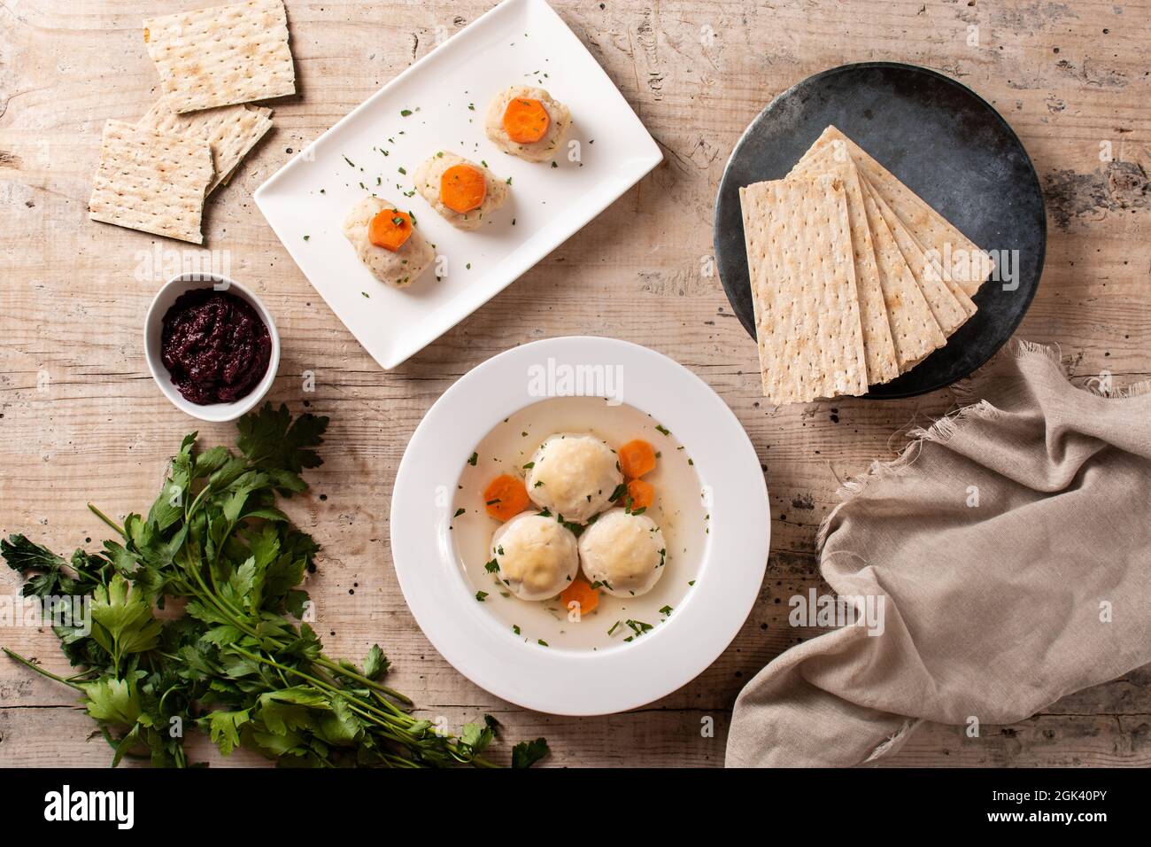 Traditionelle jüdische Matzah-Kugelsuppe, gefilter Fisch und Matzah-Brot auf Holztisch Stockfoto