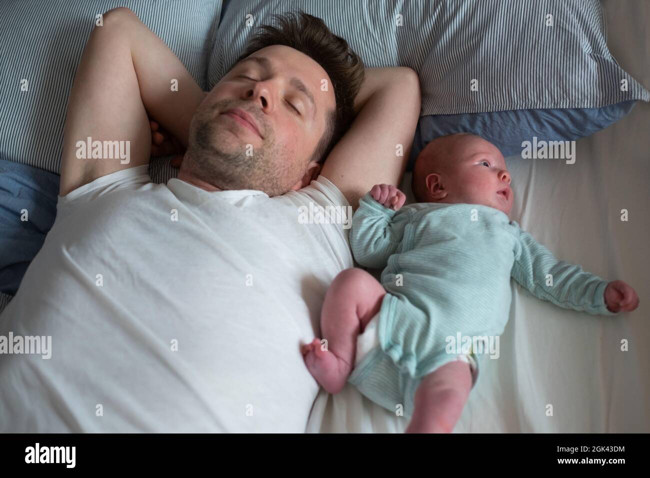 Junge kaukasische Vater und Baby Mädchen schlafen auf dem Bett zusammen. Stockfoto