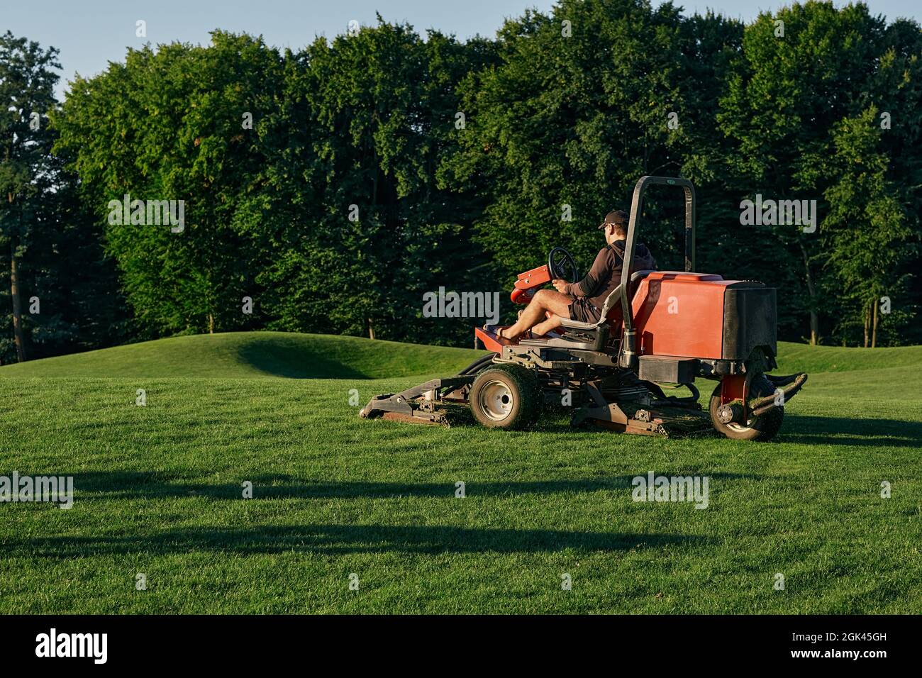 Greenkeeper. Mitarbeiter der Golfplatzverwaltung, schneidet grünes Gras Stockfoto