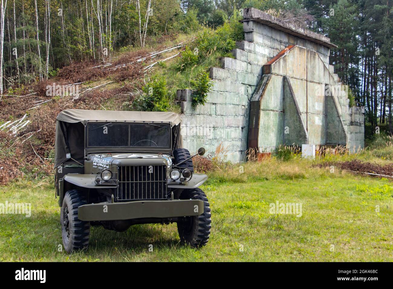 Ein historischer Geländewagen der US-Armee steht vor den Hangars auf einem ehemaligen Militärflughafen. Stockfoto