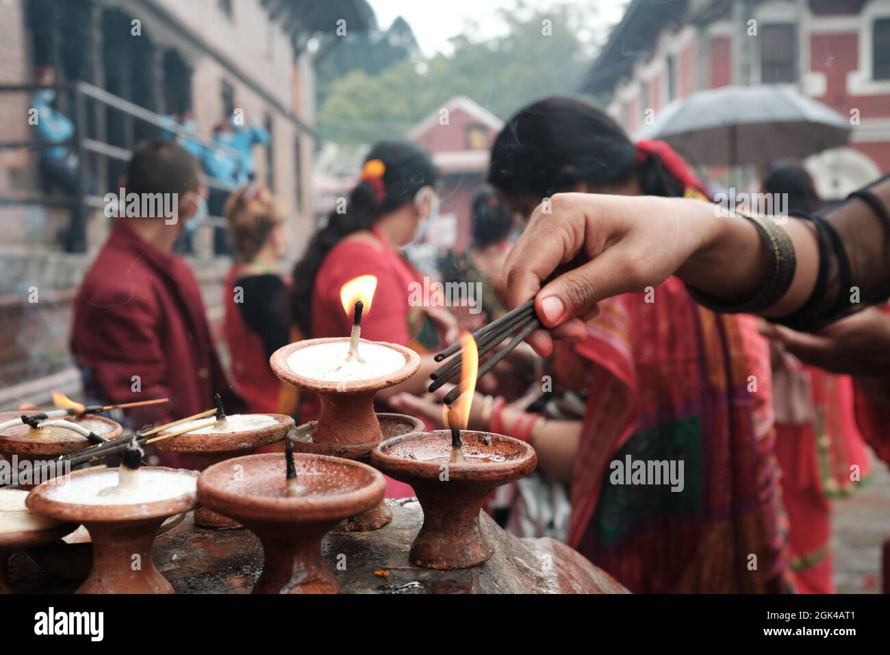 Eine Frau, die anlässlich des Teej in Pashupatinath Räucherstäbchen verbrennt Stockfoto