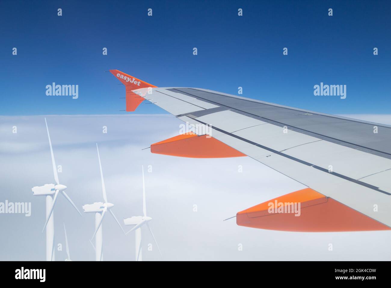 EasyJet-Flugzeug fliegt über Windenergieanlagen. Luftfahrtindustrie sauber, g... Konzept Stockfoto