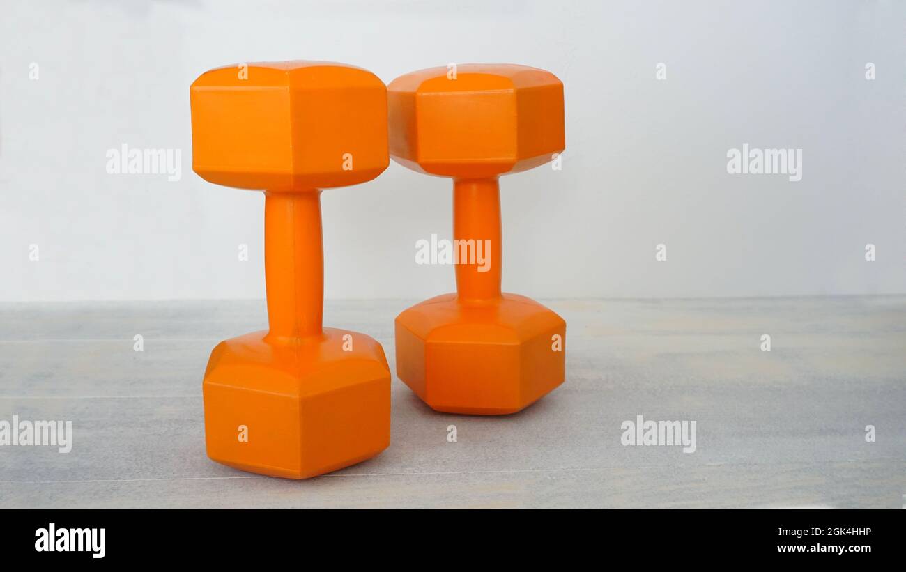 Orangefarbene Kurzhanteln Stockfoto