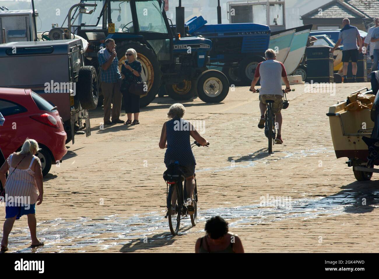 Radfahrerin auf Kopfsteinpflaster, Filey Beach, Ostküste von North Yorkshire, beschäftigt mit Urlaubern, Nordengland, Großbritannien Stockfoto