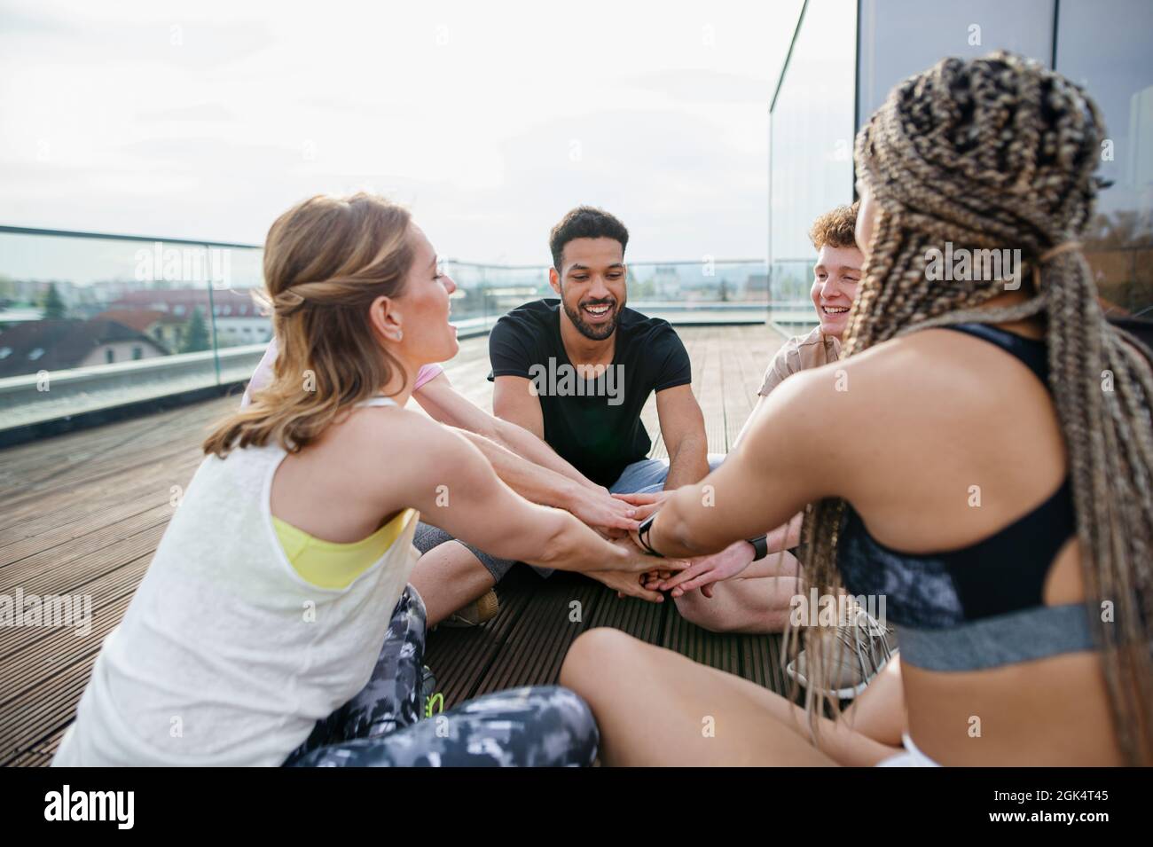 Gruppe von jungen Menschen tun Übung Stapeln Hände im Freien auf der Terrasse, Sport und gesunde Lebensweise Konzept. Stockfoto