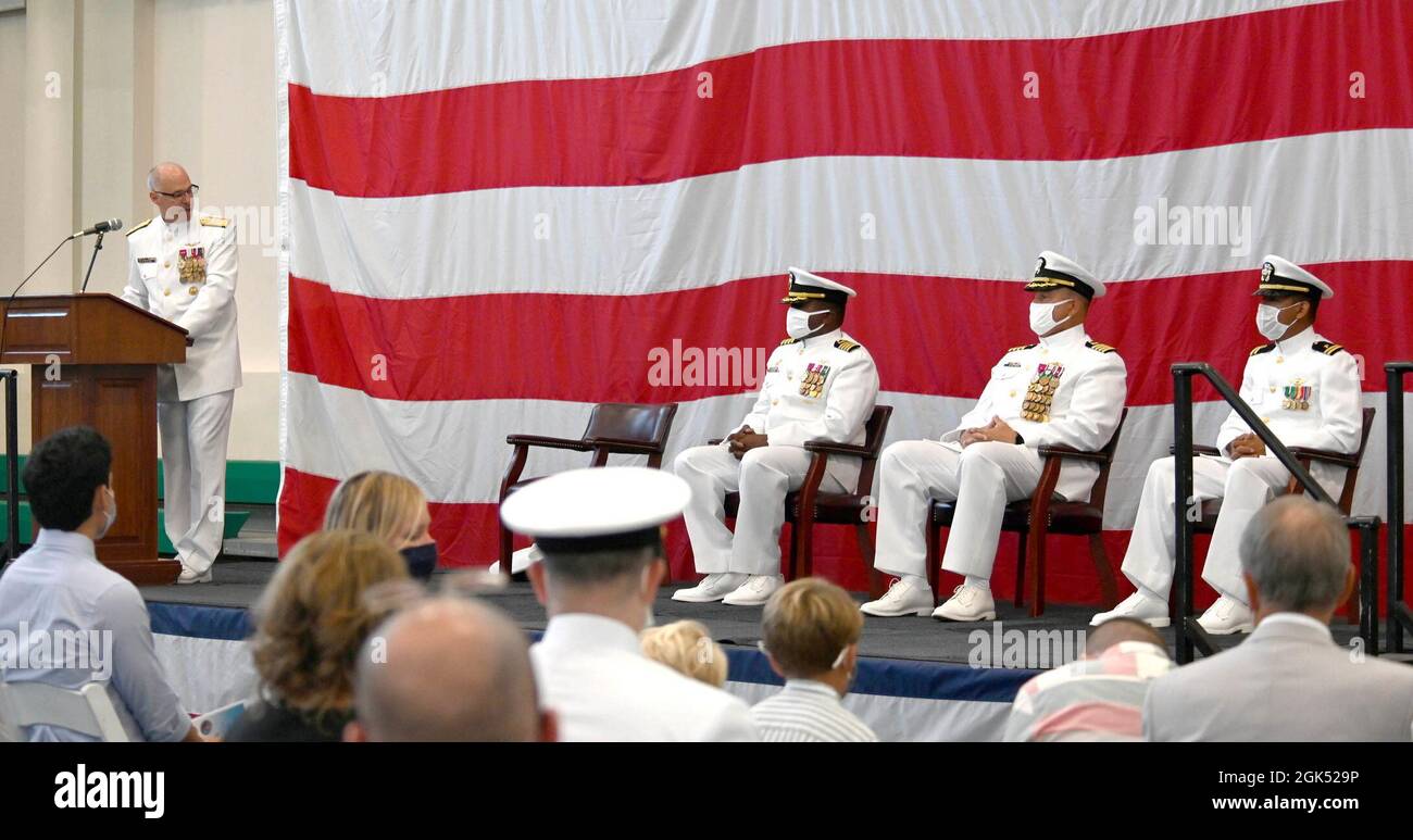 Hinterer Adm. Scott Gray (stehend), Kommandant, Navy Region Europe, Africa, Central, Hält Bemerkungen während einer Zeremonie zur Änderung des Kommandos, die vom Naval Supply Systems Command Fleet Logistics Center Sigonella am 3. August 2021 im Naval Air Station Sigonella, Italien, abgehalten wurde. Während der Zeremonie entließ Capt. Douglas S. MacKenzie (zweiter von rechts auf dem Dais) Capt. Alsandro H. Turner (zweiter von links auf dem Dais) als Kommandanten. Stockfoto