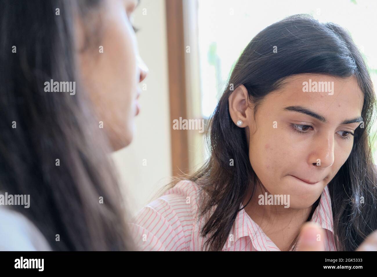 Nahaufnahme des Gesichtsausdrucks eines Mädchens während des Gesprächs Stockfoto
