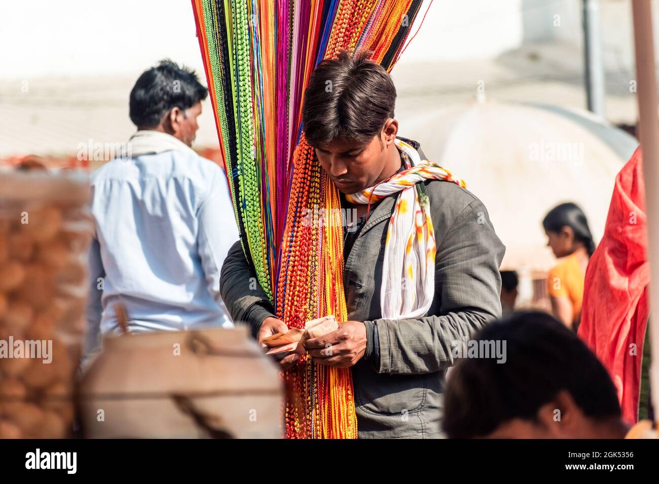 Orchha, Madhya Pradesh, Indien - 2019. März: Ein Straßenhändler, der bunte Textilien auf einem überfüllten Markt in Orchha verkauft. Stockfoto