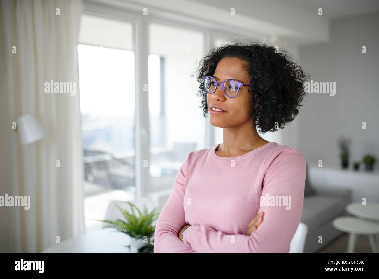 Porträt einer glücklichen reifen Frau zuhause, die zur Seite schaut. Stockfoto