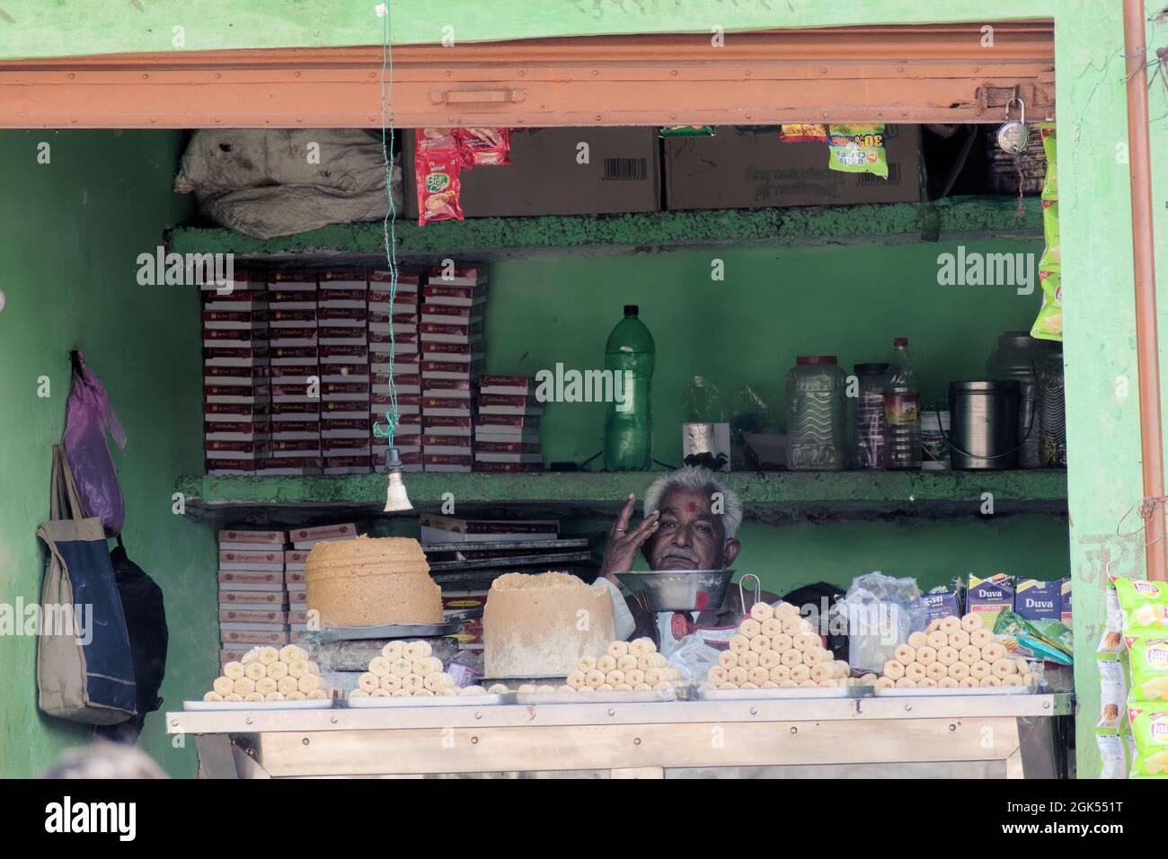Orchha, Madhya Pradesh, Indien - 2019. März: Ein indischer Ladenbesitzer, der in seinem alten rustikalen Süßigenshop sitzt und traurig und besorgt aussieht. Stockfoto