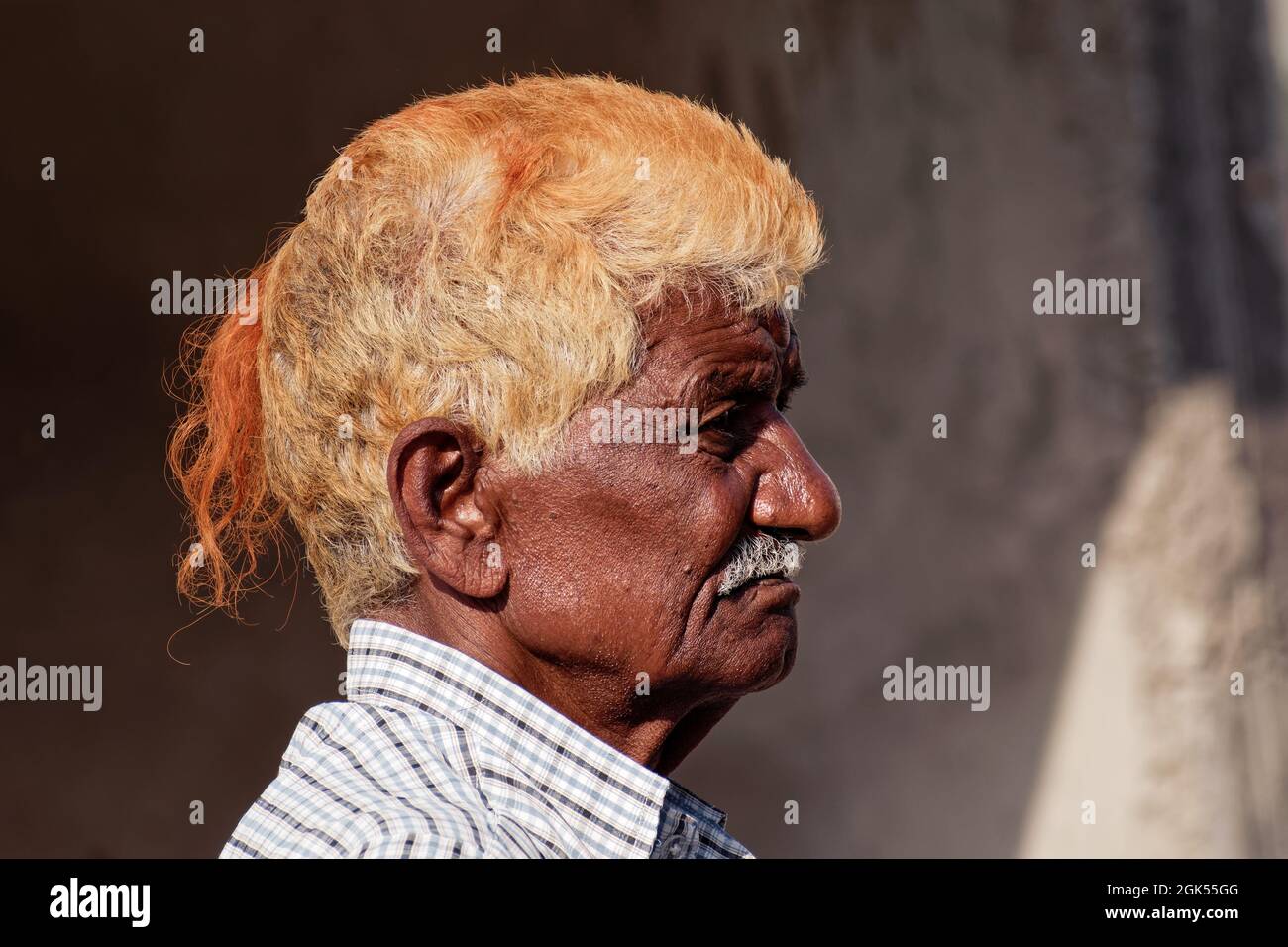 Orchha, Madhya Pradesh, Indien - März 2019: Ehrliches Seitenportrait eines älteren indischen Mannes mit orange gefärbtem Haar. Stockfoto