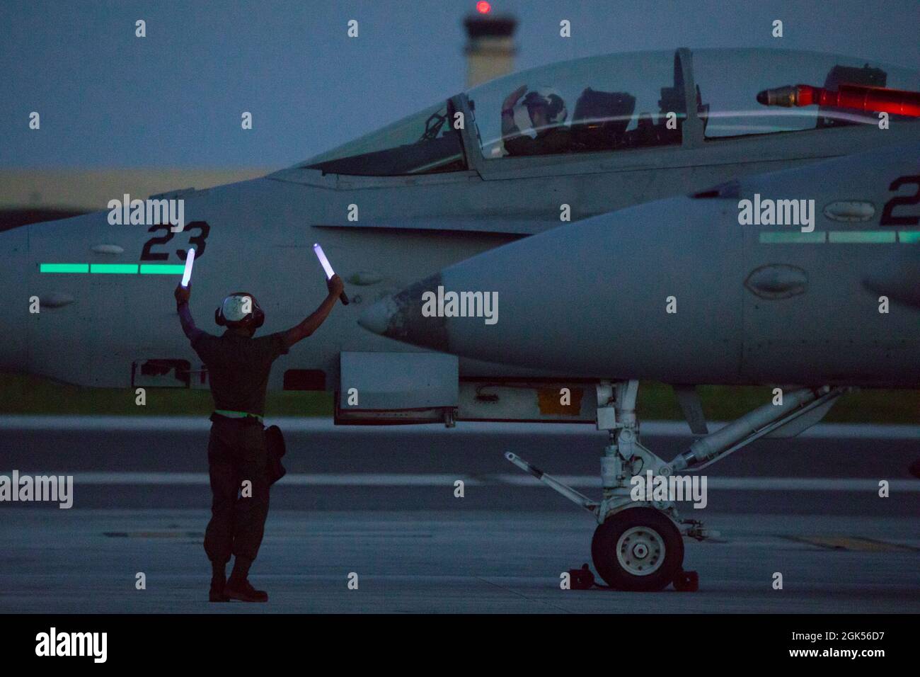 Eine US-Marine mit Marine Fighter Attack Squadron (VMFA) 232 bereitet sich auf den Start eines F/A-18D Hornet-Flugzeugs auf der Andersen Air Force Base, Guam, während Pacific Iron 2021, 4. August 2021 vor. Pacific Iron 2021 konzentriert sich auf den Einsatz, den Betrieb und die Unterstützung von Kräften aus kleineren, verstreuten Stützpunkten in der Region Indo-Pazifik. Stockfoto