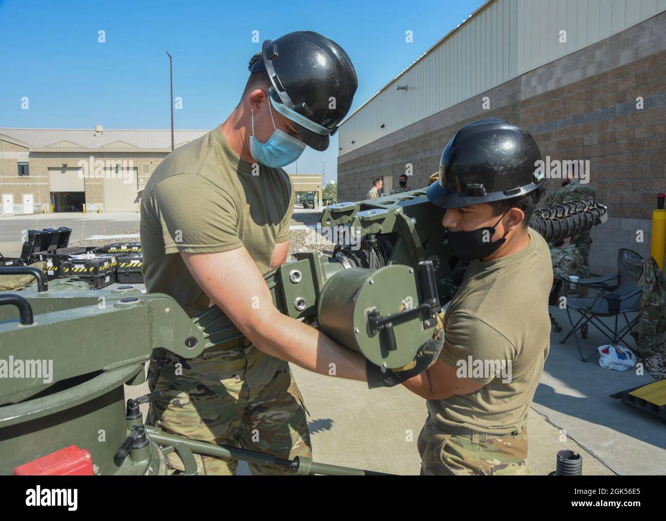 Techniker der US Air Force 726. Air Control Squadron Radio: Airman 1st Class Ashton Foley, (links) und Airman 1st Class Jose Salazar arbeiten zusammen, um eine Wagenheberschraube in den Sockel einer kleinen Aperture-Antenne (SAA) auf der Mountain Home Air Force Base, Idaho, 4. August 2021 zu installieren. Die SAA und die elektronischen Gehäuse sind die Komponenten, die einen Multiband-Masseanschluss bilden. Stockfoto