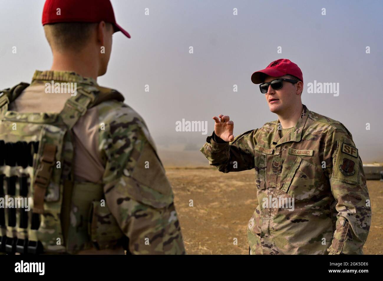 US Air Force Tech. Sgt. Blake Burden, der nicht beauftragte Offizier der 126. Sicherheitskräfte-Geschwader, der für Kampfwaffen zuständig ist, spricht mit anderen Instruktoren für Kampfwaffen im Camp San Luis Obispo, Kalifornien, 6. August 2021. Die Ausbilder der Illinois Air National Guard Gruppe bereiteten sich auf die tagelang Schulung von Feuerwaffen-Systemen vor, die für ihr Berufsfeld erforderlich waren. Stockfoto