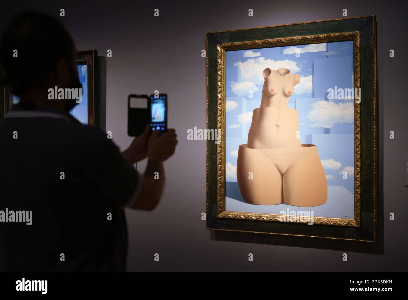 Ein Besucher fotografiert die Werke der Ausstellung „The Magritte Machine“, der ersten Retrospektive in Madrid, die dem belgischen Künstler René Magritte gewidmet ist, einem der größten Vertreter des Surrealismus, die von morgen bis zum 30. Januar 2022 im Museo Nacional Thyssen-Bornemisza in Madrid besichtigt werden kann. (Foto von Atilano Garcia / SOPA Images/Sipa USA) Stockfoto