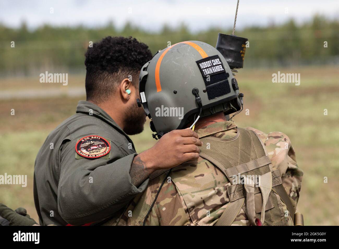 Soldaten der Nationalgarde der Alaska-Armee, die dem 1. Bataillon, dem 207. Luftfahrtregiment, zugewiesen wurden, führen zusammen mit den Flugbegleitern ein medizinisches Evakuierungshubtraining mit dem 39. Luftlift-Geschwader aus Texas in der Nähe des Bryant Army Airfield auf der Joint Base Elmendorf-Richardson am 9. August 2021 durch. Die Militäranwärter verwendeten einen UH-60 Blackhawk und C-130 Hercules, um eine reale Extraktion zu simulieren. Stockfoto