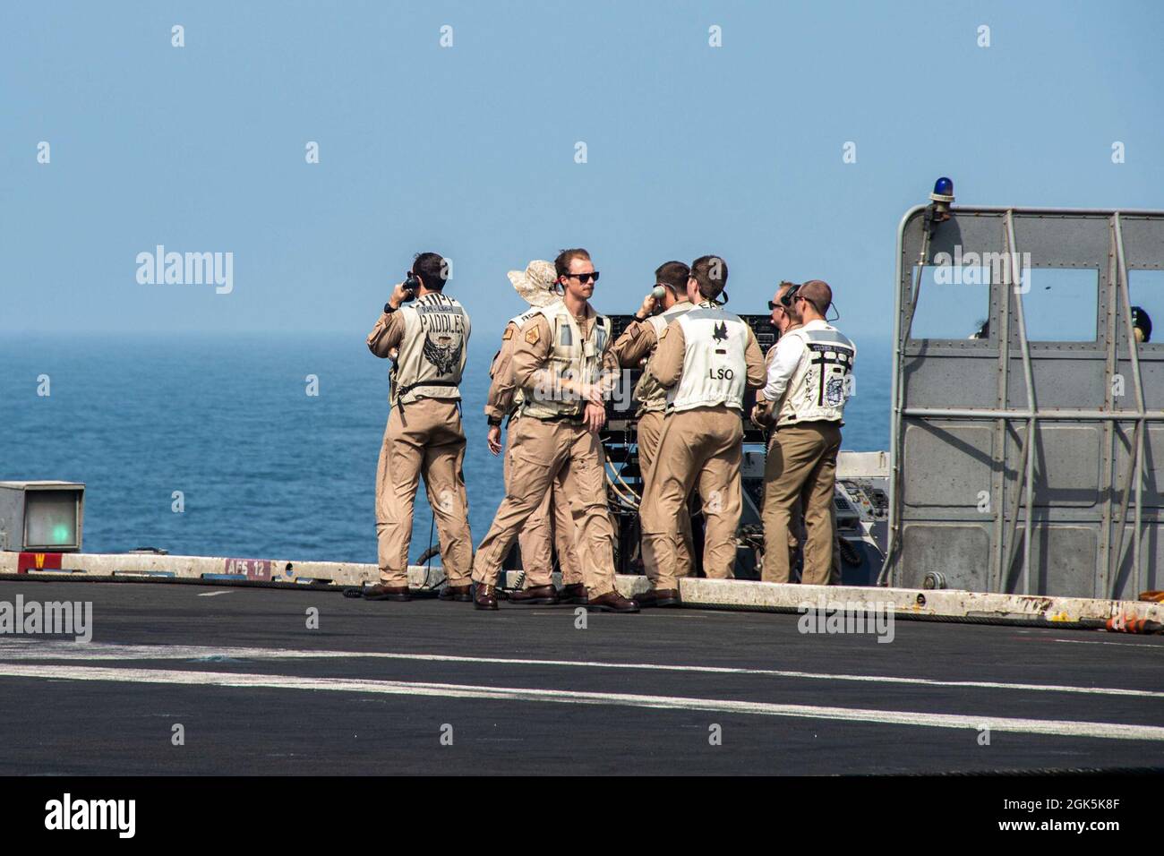 210809-N-WS494-1065 ARABIAN SEA (AUG 9, 2021) – Landing Signal Officers signalisieren, dass Flugzeuge auf dem Flugdeck des Flugzeugträgers USS Ronald Reagan (CVN 76) in der Arabischen See landen, August 9. Ronald Reagan wird in den Einsatzbereich der 5. US-Flotte eingesetzt, um Marineinteraktionen zu unterstützen, um die maritime Stabilität und Sicherheit in der Zentralregion zu gewährleisten und das Mittelmeer und den Pazifik durch den westlichen Indischen Ozean und drei strategische Engpässe zu verbinden. Stockfoto