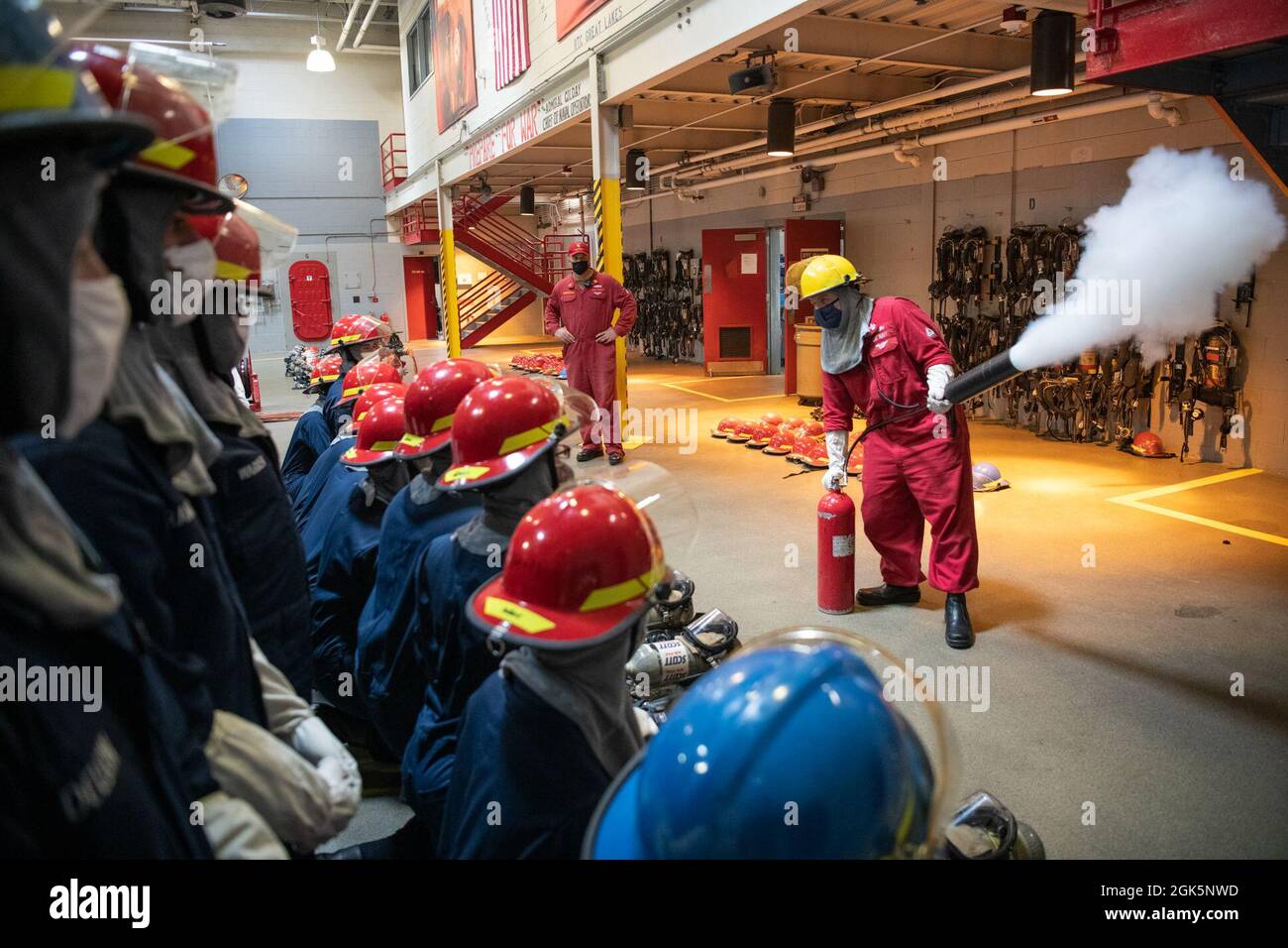 Rekruten wird gezeigt, wie sie eine CO2-Flasche vor einer Feuerwehrübung im USS Chief Fire Fighter Trainer bei Recruit Training Command verwenden. Mehr als 40,000 Rekruten trainieren jährlich im einzigen Bootcamp der Marine. Stockfoto