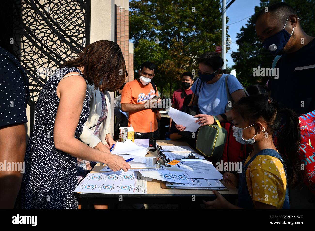 Familien stellen sich vor, um ihre Kinder zum persönlichen Lernen abzusetzen, während die öffentlichen Schulen von New York City am 13. September 2021 im Stadtteil Queens von New York wiedereröffnet werden. Das Schulsystem der öffentlichen Schulen in New York City, das seit März 2020 geschlossen wurde und mit über einer Million Kindern das größte in den Vereinigten Staaten ist, kehrt zu einem vollständigen Unterricht in der Klasse zurück, ohne die Option des Fernlernens zu nutzen; Die Lehrer werden voraussichtlich gegen COVID-19 geimpft, und die Schüler müssen während des Unterrichts Gesichtsschutzmasken tragen. (Foto von Anthony Behar/Sipa USA) Stockfoto