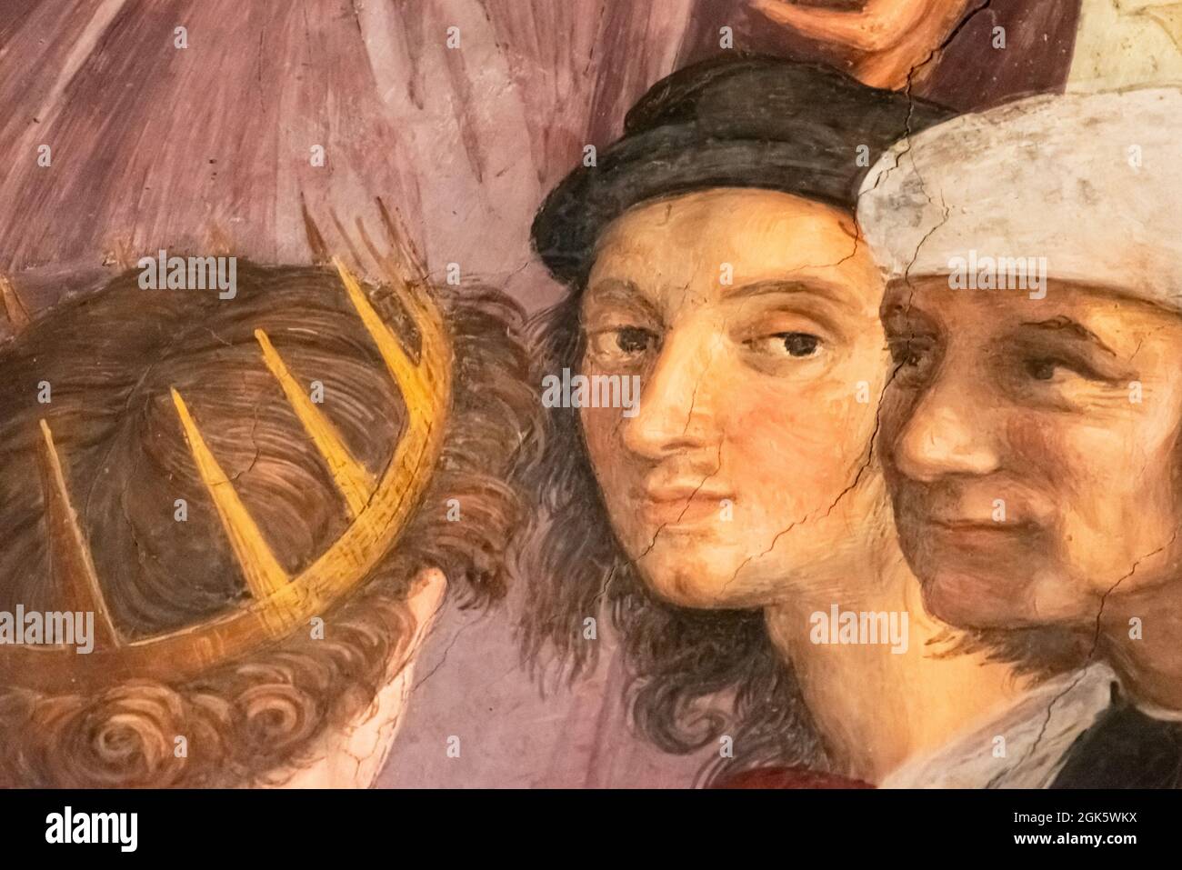 Detail einer mittelalterlichen Malerei, die in Nahaufnahme die Gesichter zweier Männer zeigt, die mit einem dritten Mann sprechen, der eine goldene Krone trägt Stockfoto