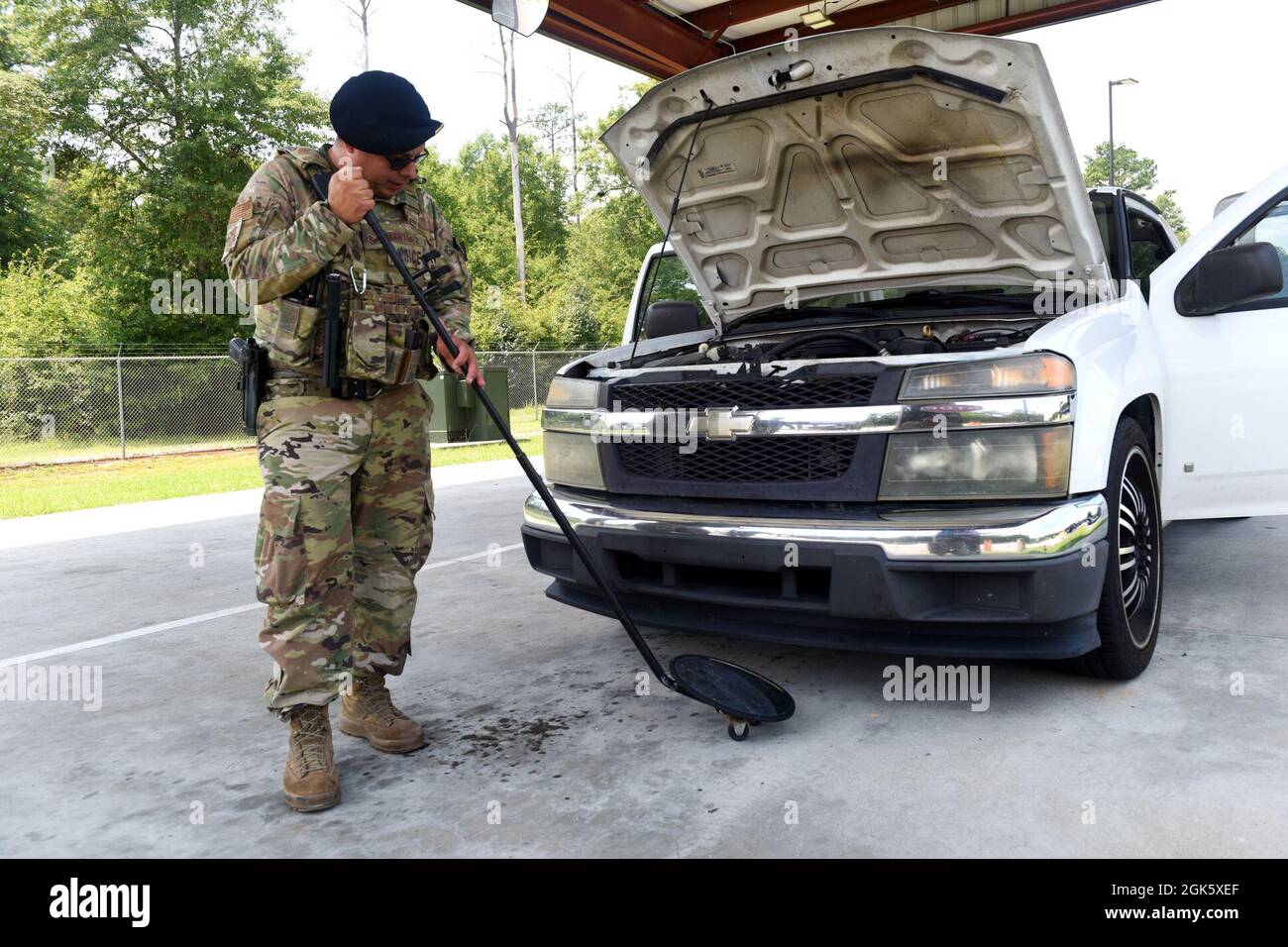 US Air Force Staff Sgt. Daniel Martinez, nicht beauftragter Offizier der 169th Security Forces Squadron, verantwortlich für das Besucherkontrollzentrum, inspiziert ein entgegenkommendes Fahrzeug auf nicht autorisierte Substanzen und Schusswaffen am Vordertor der McEntire Joint National Guard Base, South Carolina, 10. August 2021. Stockfoto