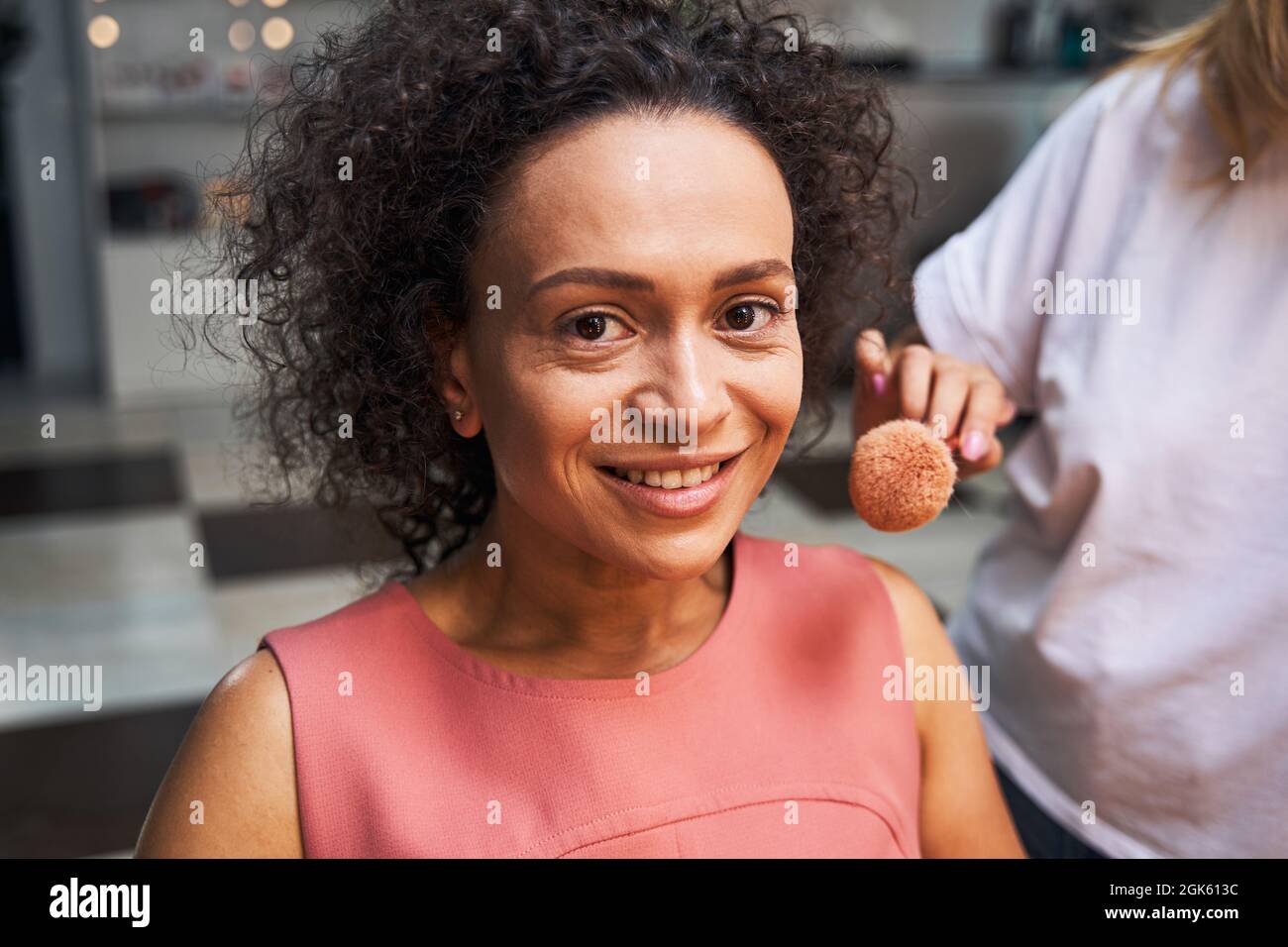 Porträt einer glücklichen weiblichen Person, die Make-up macht Stockfoto