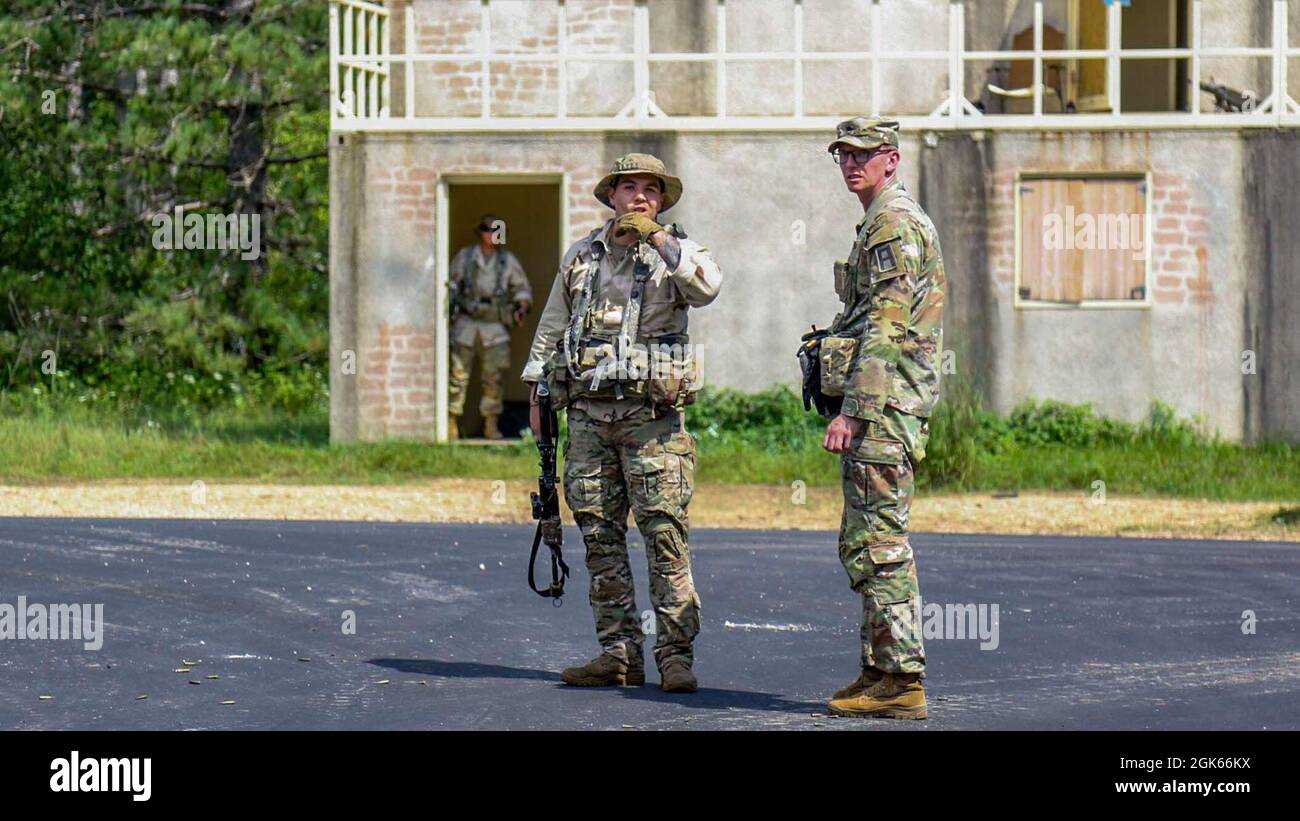 Sgt. Klasse Joseph Tully (rechts), ein Beobachtertrainer/Trainer mit 4. Bataillon, 409. Brigade-Unterstützungsbataillon, 4. Kavallerie-Multifunktionsbrigade, Er überlässt einen OPFOR-Soldaten, der der 10. Bergdivision zugewiesen wurde, nachdem die OPFOR einen Konvoi als Teil einer situationsbezogenen Trainingsbahn bei der Kampfunterstützungs-Trainingsübung überfallen hatte 78-21-04 am 12. August 2021 in Fort McCoy, Wisconsin. OC/TS sind Fachexperten auf dem Gebiet der Doktrin und ihrer spezifischen Kampffunktionen. Stockfoto