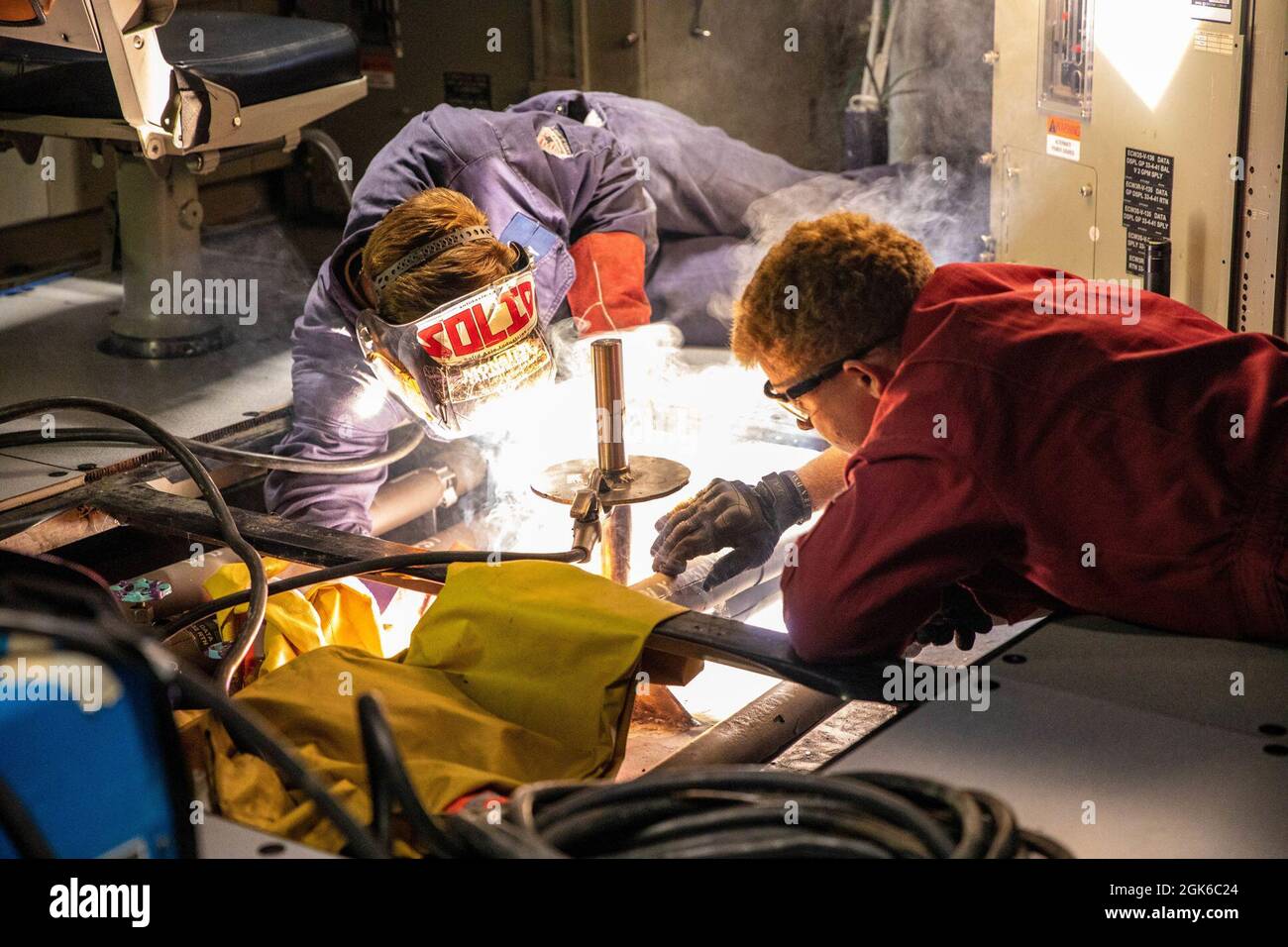 ARABISCHES MEER (Aug 13, 2021) – Matrosen führen Reparaturen im Combat Information Center an Bord des Lenkraketen-Zerstörers USS Halsey (DDG 97) im Arabischen Meer durch, August 13. Halsey wird im Einsatzgebiet der 5. US-Flotte eingesetzt, um Marinestützpunkte zu unterstützen, um die maritime Stabilität und Sicherheit in der Zentralregion zu gewährleisten und das Mittelmeer und den Pazifik durch den westlichen Indischen Ozean und drei strategische Engpässe zu verbinden. Stockfoto