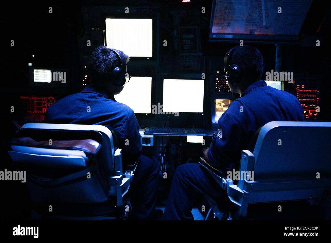 ARABISCHES MEER (Aug 13, 2021) – Matrosen stehen im Combat Information Center an Bord des Lenkraketen-Zerstörers USS Halsey (DDG 97) im Arabischen Meer, 13. August. Halsey wird im Einsatzgebiet der 5. US-Flotte eingesetzt, um Marinestützpunkte zu unterstützen, um die maritime Stabilität und Sicherheit in der Zentralregion zu gewährleisten und das Mittelmeer und den Pazifik durch den westlichen Indischen Ozean und drei strategische Engpässe zu verbinden. Stockfoto