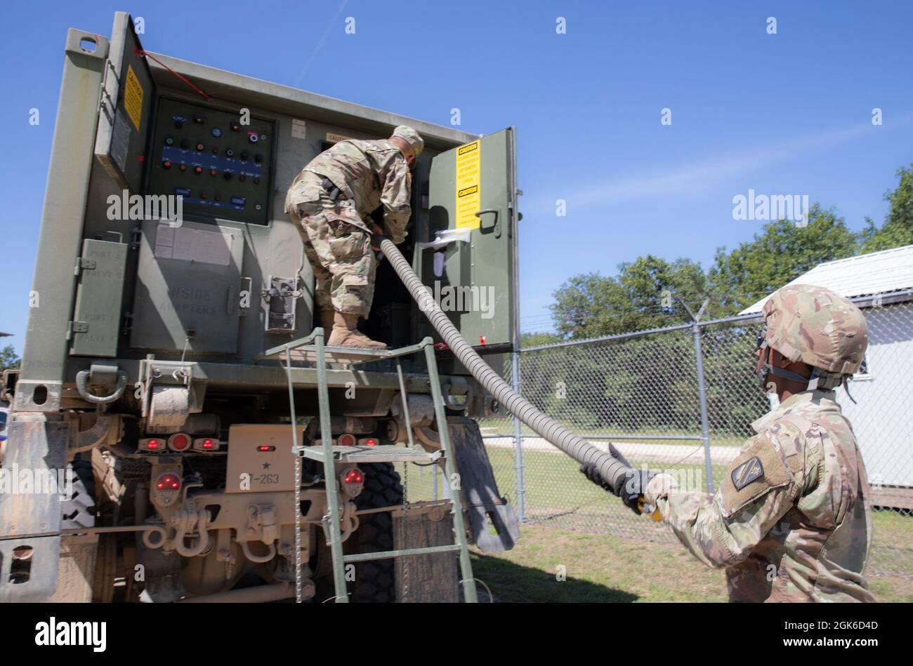 Pfc. Michael Landry, Spezialist für Wasseraufbereitung, Right, und SPC. Calvin McWhorter, ein Mechaniker für Radfahrzeuge, beide zusammen mit der 303rd Quartermaster Company aus Lake Charles, Louisiana, bereiten sich darauf vor, während der Combat Support Training Exercise (CSTX) in Fort McCoy, Wisconsin, am 14. August 2021 einen Wasserbüffel zu füllen. CSTX bereitet Soldaten durch Szenarien vor, die den Einsatz von Konflikten gegen einen Gegner in der Nähe simulieren. Die richtige Flüssigkeitszufuhr trägt zur Soldier Readiness bei, indem sie die Widerstandsfähigkeit gegen hitzebedingte Verletzungen verbessert. Stockfoto