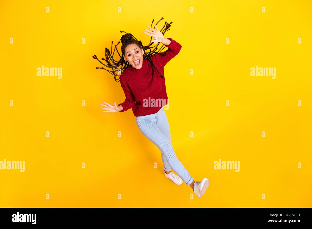 In voller Länge Hochwinkel Foto von lustigen charmanten dunklen Haut Frau gekleidet roten Pullover tanzen lächelnd isoliert gelbe Farbe Hintergrund Stockfoto