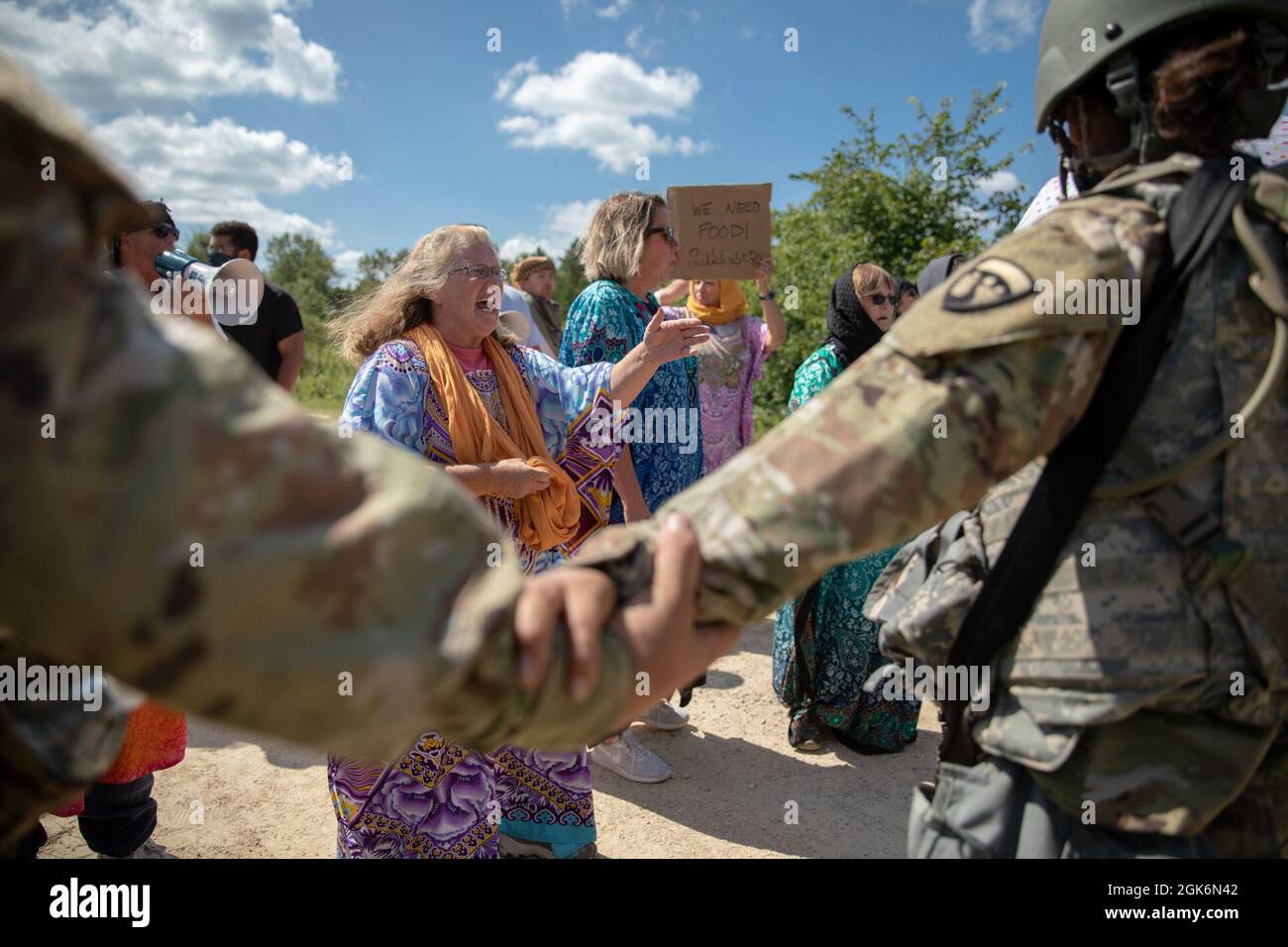 Soldaten schaffen mit der 376. Human Resources Company in Bell, Kalifornien, eine menschliche Barriere, um eine Gruppe von zivilen Demonstranten, die den Einreisekontrollpunkt passieren, davon abzuhalten, bei einer Kampfunterstützungs-Trainingsübung (CSTX) in Fort McCoy, Wisconsin, am 17. August 2021, vorzurücken. CSTX ermöglicht es Einheiten der Nationalgarde und der Armeereserven, die Bereitschaft zur Vorbereitung auf zukünftige Kampfeinsätze durch realistische Szenarien zu erreichen, zu verbessern und aufrechtzuerhalten, die von Beobachtern, Trainern und Trainern bewertet werden. Stockfoto