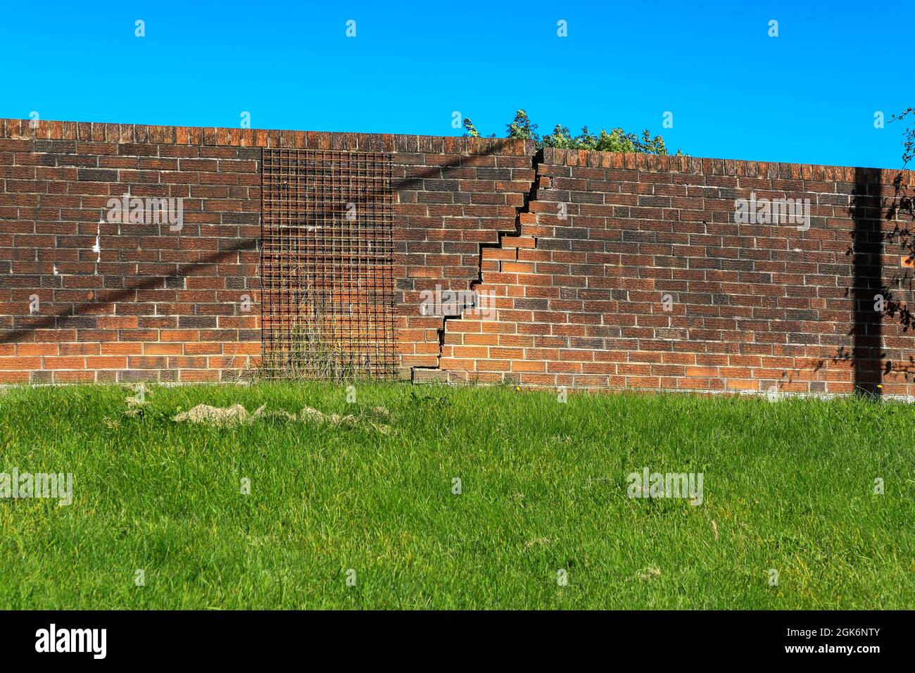 Eine Mauer, die aufgrund von Bodensenkungen gerissen ist und die Fundamente nicht stark genug waren, England, Großbritannien Stockfoto