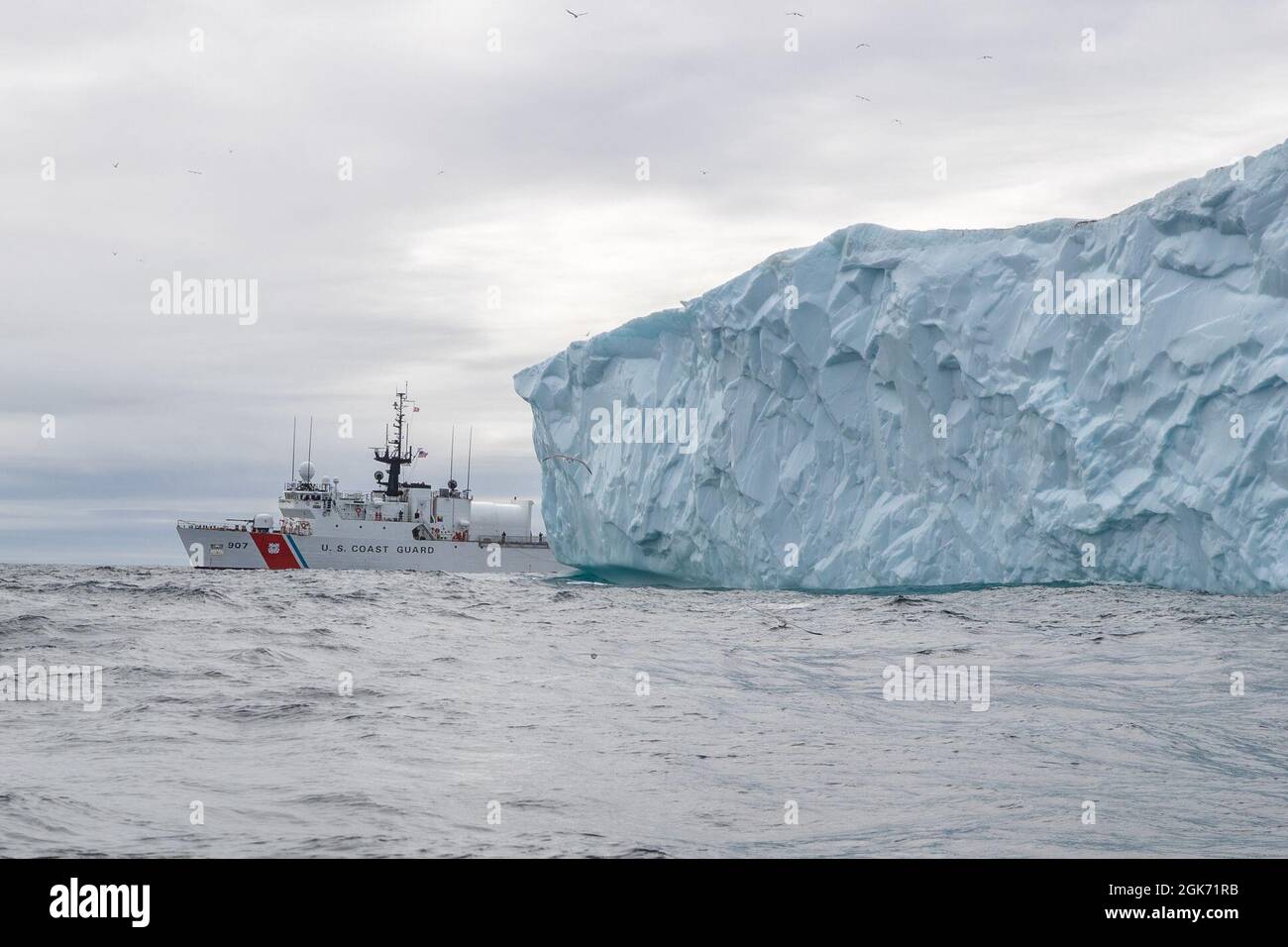 LABRADOR SEA -- (Aug 19, 2021) die USCGC Escanaba (WMEC 907) durchfährt einen Eisberg in der Labradorsee. Die Fräser sind in der Region am Ende der warmen Jahreszeit in Betrieb, wodurch das Risiko reduziert wird. Die Escanaba ist ein 270 Meter langer, berühmter Mittelausdauerschneider mit einer Besatzung von rund 100 Personen und führt Missionen durch, die die Sicherheit im Seeverkehr und die Strafverfolgung betonen Stockfoto