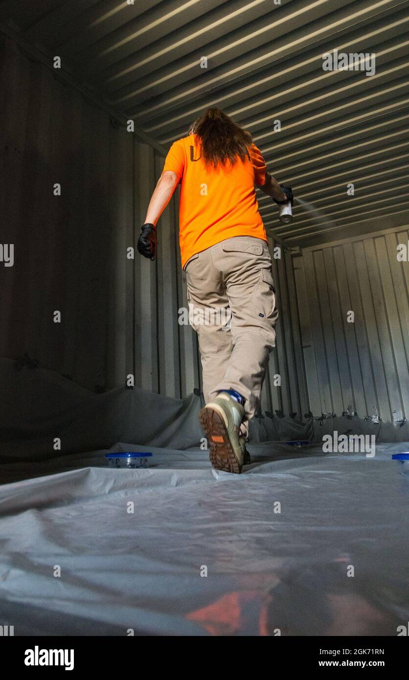 Emily Wallis, Laborantin des US-Landwirtschaftsministeriums für biologische Wissenschaft, veröffentlicht eine Anwendung von 10 % des Insektizids D-Phenothrin zur Eliminierung von Spotted Lanternflies in Kunststoffbehältern auf der Dover Air Force Base, Delaware, 19. August 2021. Drei 1,200 Kubikfuß große Transportcontainer wurden verwendet, um eine Flugzeugfrachtfläche zu simulieren, in der sechs modifizierte Lebensmittelbehälter aus Kunststoff, in denen jeweils das invasive Insekt enthalten war, in jedem Transportcontainer platziert wurden. Stockfoto