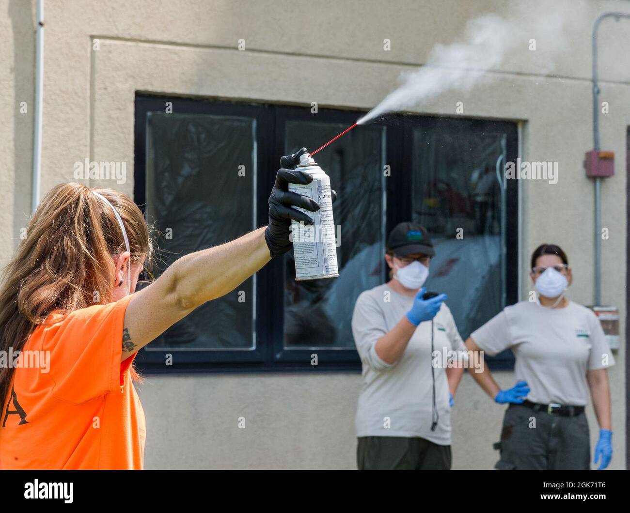 Emily Wallis, Laborantin des US-Landwirtschaftsministeriums für biologische Wissenschaft, veröffentlicht eine sechs-Sekunden-Anwendung von 10 % d-Phenothrin-Insektizid auf dem Luftwaffenstützpunkt Dover, Delaware, 19. August 2021. Melissa Benzinger McGlynn, Laborantin der USDA für biologische Wissenschaften, hat die Freisetzung zeitlich festgelegt, da Lianmarie Colon Torres, USDA-Spezialistin für Pflanzenschutz, eine optimale Anwendungszeit für Spotted Lanternfly-Experimente aufgezeichnet und formuliert hat. Stockfoto