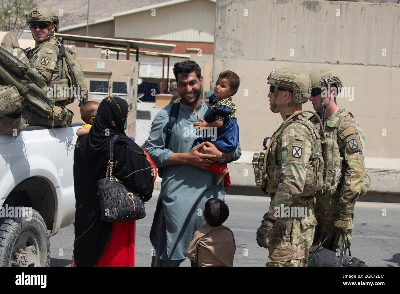 Soldaten der 10. Bergdivision eskortieren Evakuierte am Hamid Karzai International Airport, Afghanistan, August 20. US-Dienstmitglieder unterstützen das Außenministerium bei einer nicht-kämpferischen Evakuierungsoperation (NEO) in Afghanistan. Stockfoto