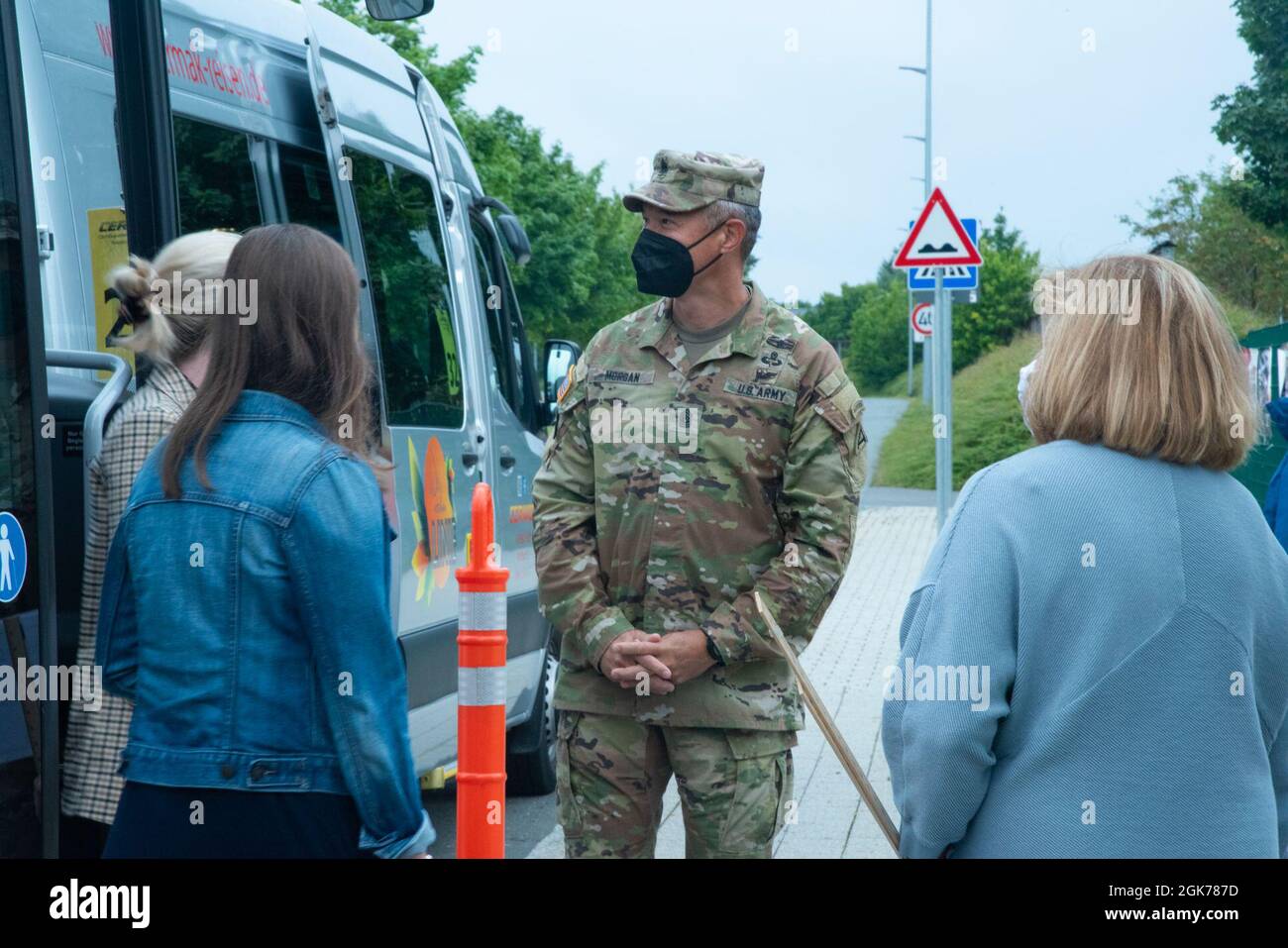 7. Armeeausbildungskommando, Befehlshaber Maj. Mark Morgan besucht die Grafenwohr Elementry School und wartet mit der Lehrkraft, um die Kinder zu begrüßen, die aus dem Bus aussteigen, um die Schule am 23. August 2021 in Grafenwoehr, Deutschland, zu betreten. Morgan begrüßte die Schüler, die aus dem Bus kamen und von den Eltern abgesetzt wurden, die den Schülern und ihren Lehrern viel Glück für das neue Schuljahr wünschten. Stockfoto