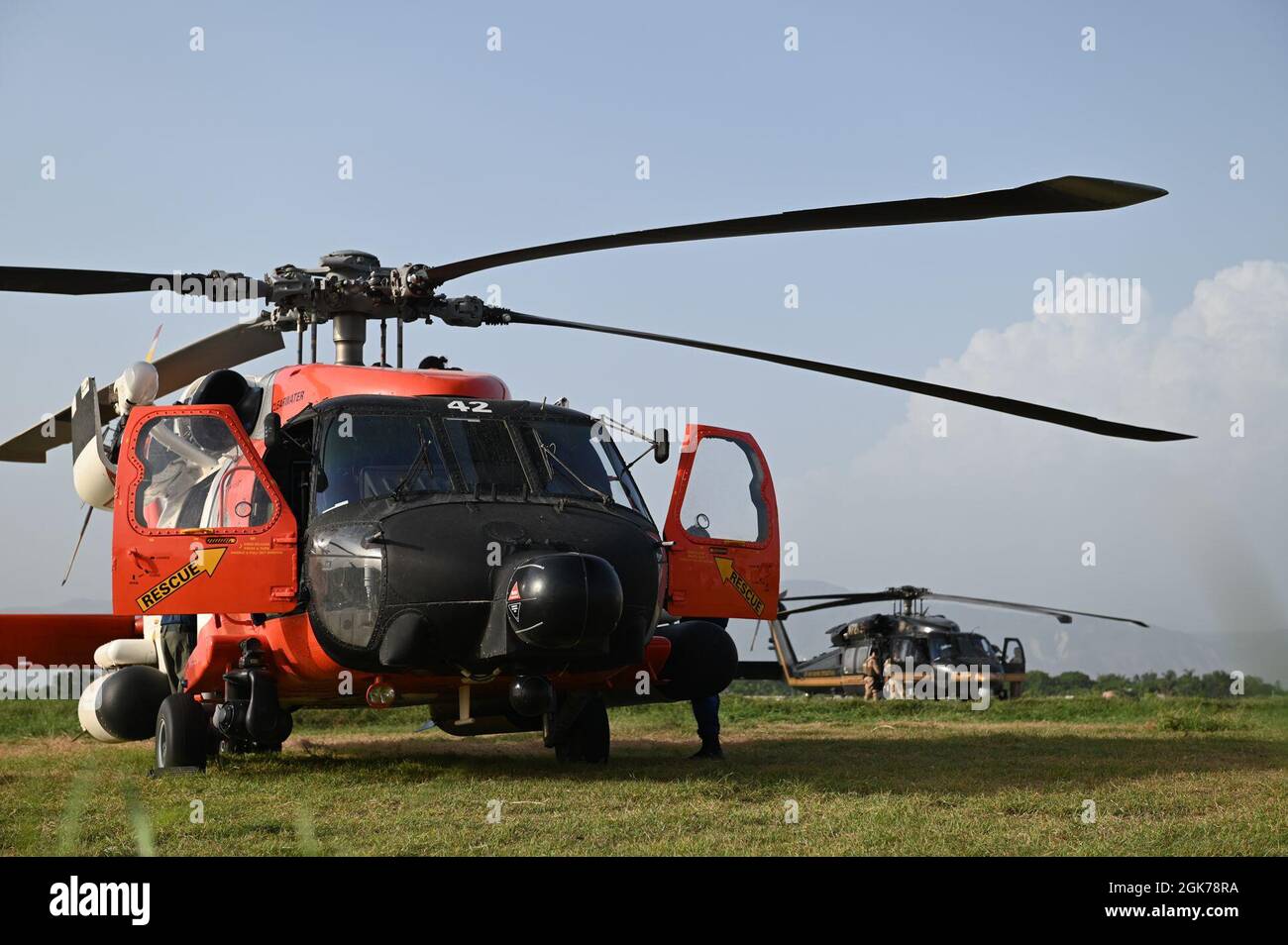 Eine MH-60 Jayhawk Helicopter-Besatzung der Küstenwache in Borinquen, Puerto Rico, und eine Hubschrauber-Besatzung der Zoll- und Grenzschutzpolizei aus Aguadilla, Puerto Rico, führen nach Flügen über Haiti in Port-au-Prince, Haiti, 23. August 2021 Nachsuchungs- und Rettungskontrollen durch. Hubschrauber und Luftbesatzungen der Küstenwache transportieren medizinisches Personal und evakuieren diejenigen, die eine höhere Versorgung benötigen. Stockfoto