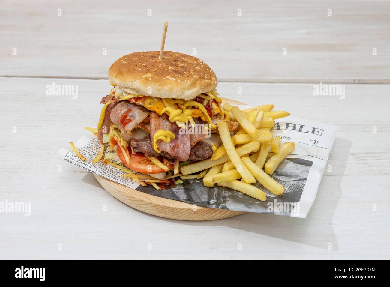 Double Beef Burger, mit viel Speck, Spiegelei, geschmolzenem Käse, Zwiebeln und Tomaten mit Ketchup und Senf und Pommes frites Stockfoto
