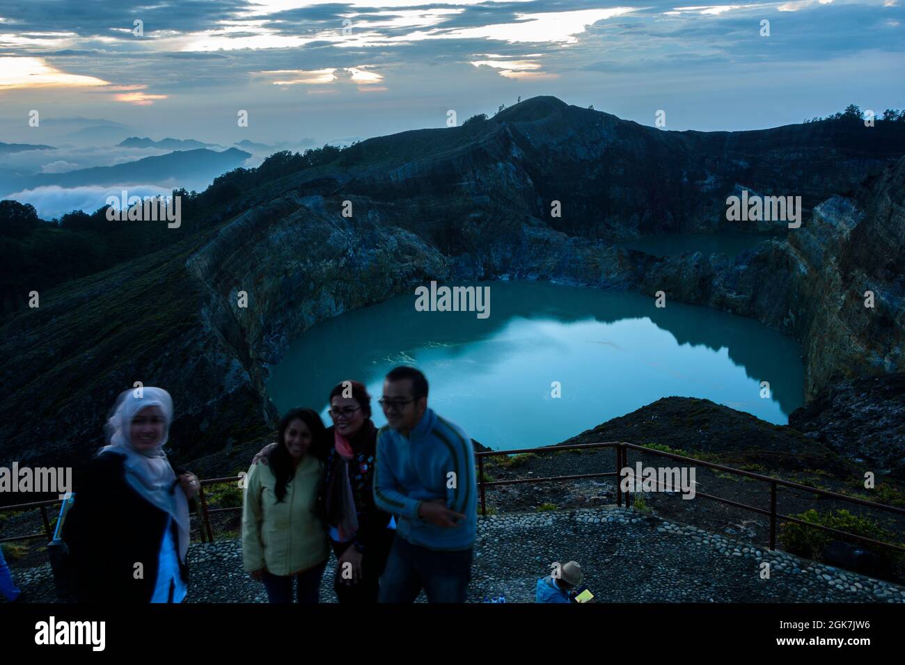 Eine Familie posiert bei Sonnenaufgang vor den Kelimutu-Krater-Seen in der Nähe von Ende.Flores Island, East Nusa Tenggare, Indonesien. Stockfoto