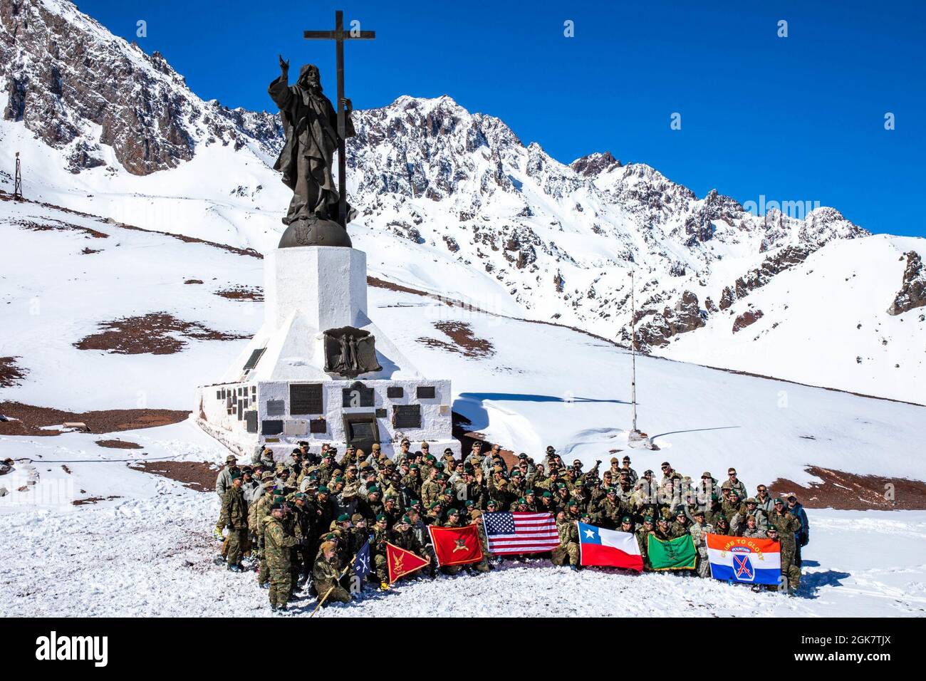 Soldaten der US-Armee werden der Bravo Company, dem 2. Bataillon, dem 87. Infanterie-Regiment, dem 2. Brigade-Kampfteam, der 10. Bergdivision, Und chilenische Soldaten der 3. Bergdivision stehen oder knien für ein Foto vor dem Christus, dem Erlöser der Anden, in der Nähe von Cancha Pelada, Chile, 29. August 2021. Soldaten führten eine Bruderschaftswanderung zum Denkmal durch, nachdem sie die Übung der Southern Vanguard 2021 zwischen US- und chilenischen Soldaten absolviert hatten. Stockfoto
